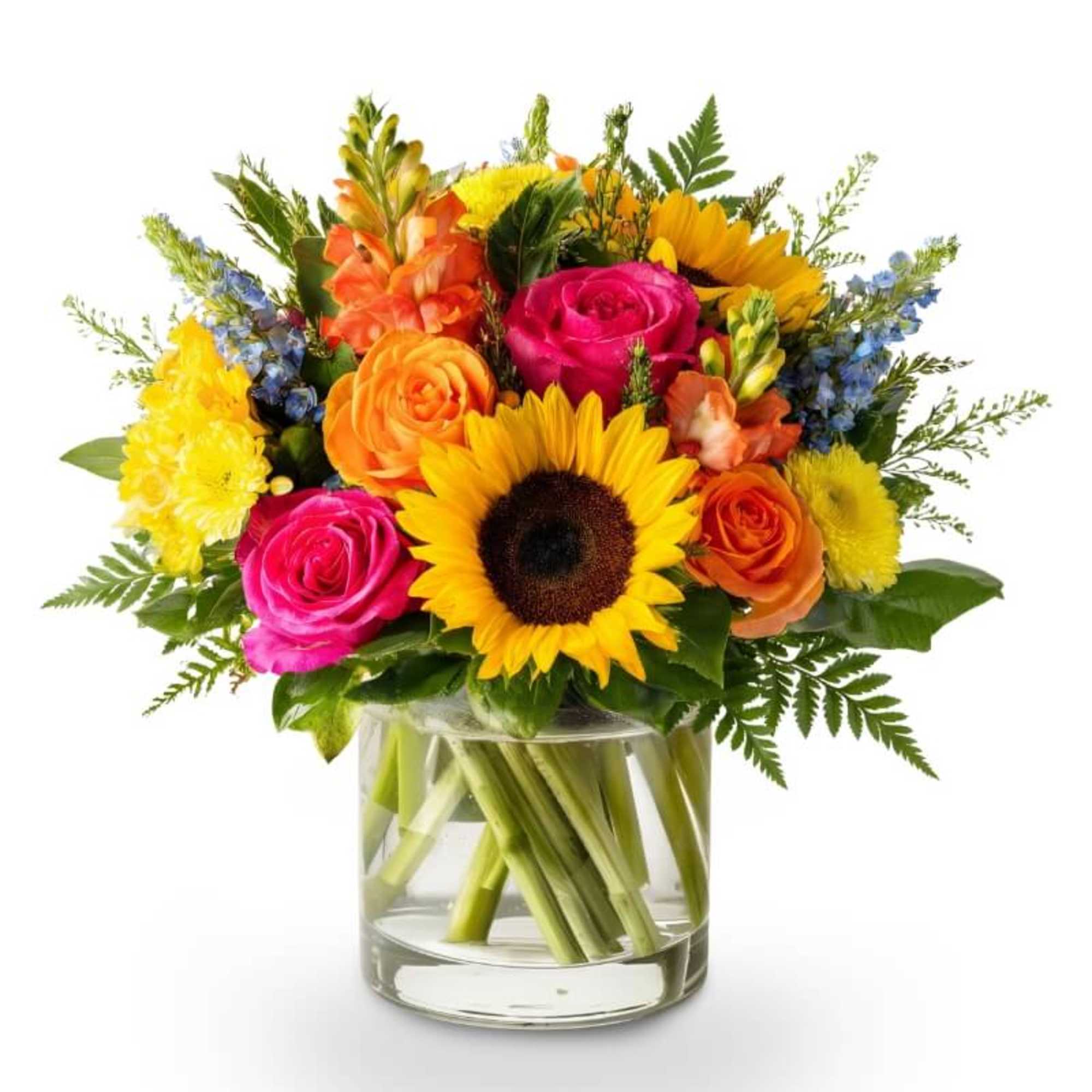 Bright mixed bouquet with sunflowers and roses in a clear glass vase