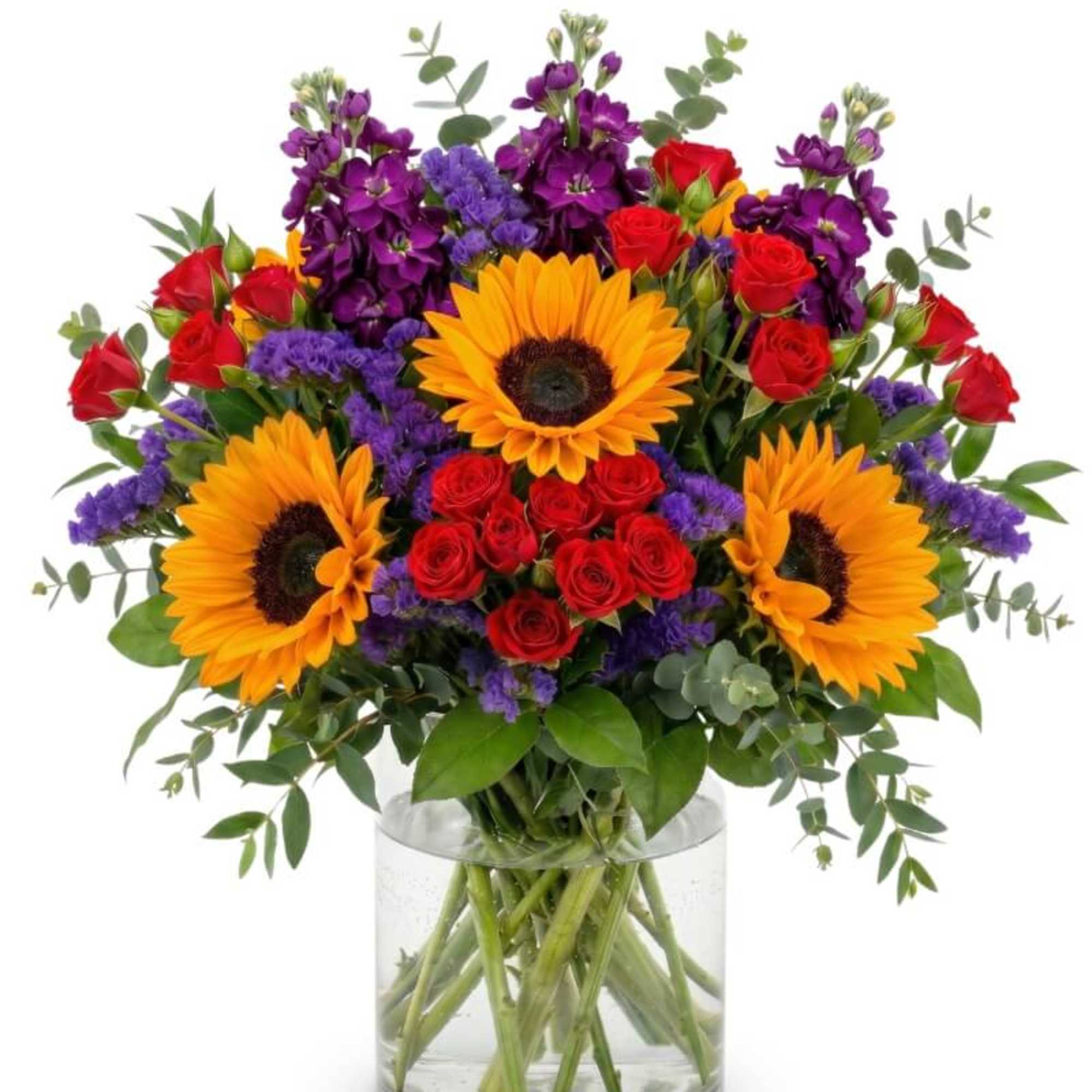 Bouquet of sunflowers, red roses, and purple flowers in a glass vase