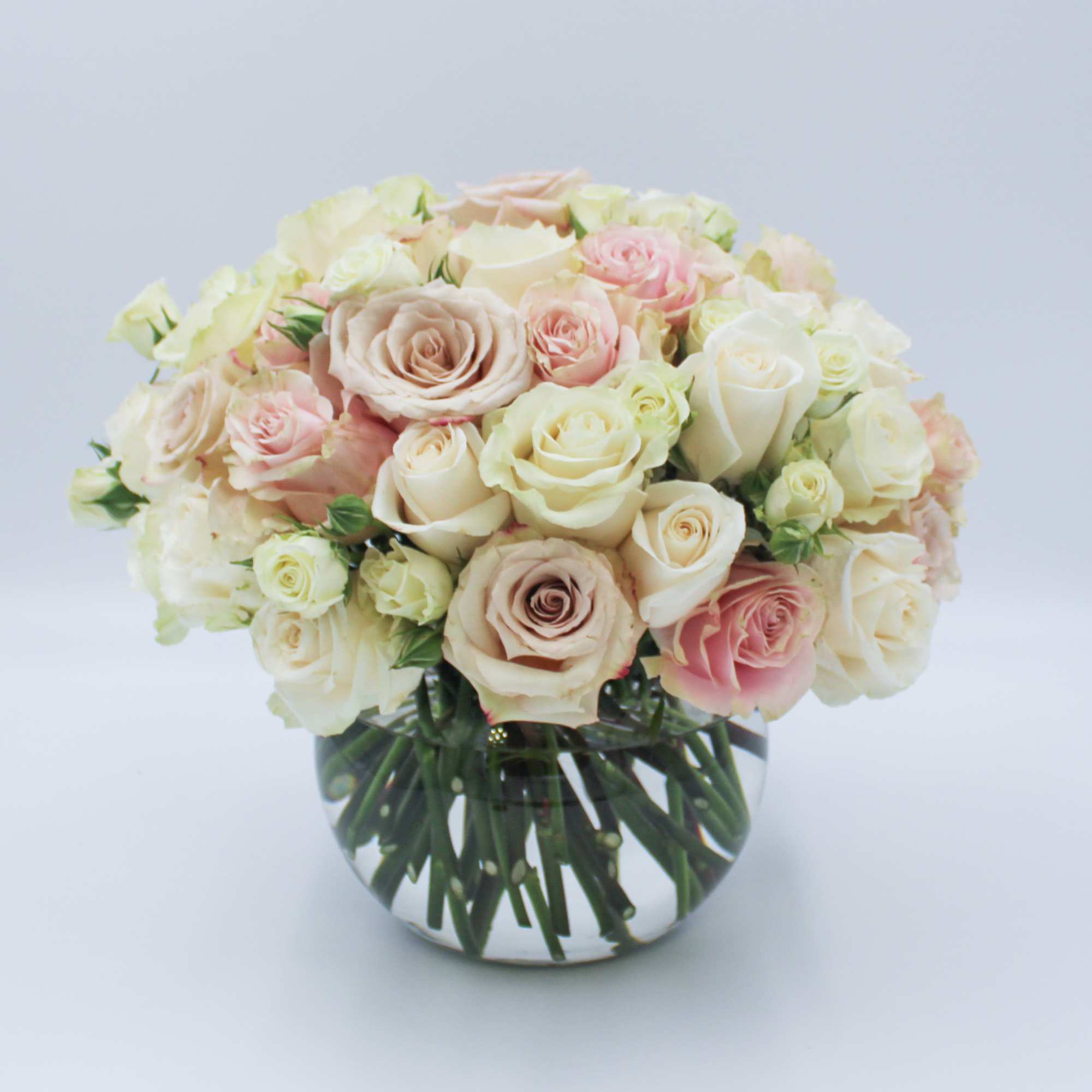 Bouquet of pale pink and cream roses in a clear glass vase