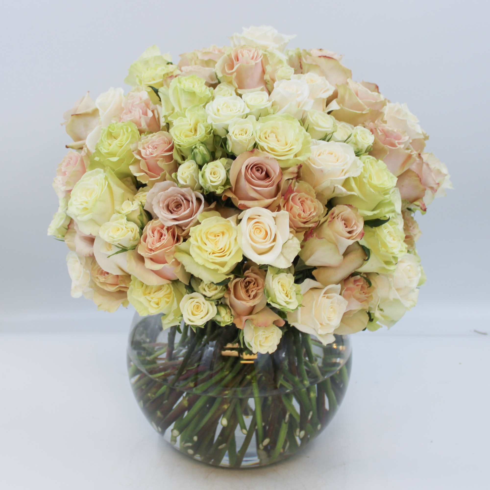 Bouquet of pale roses in a round glass vase