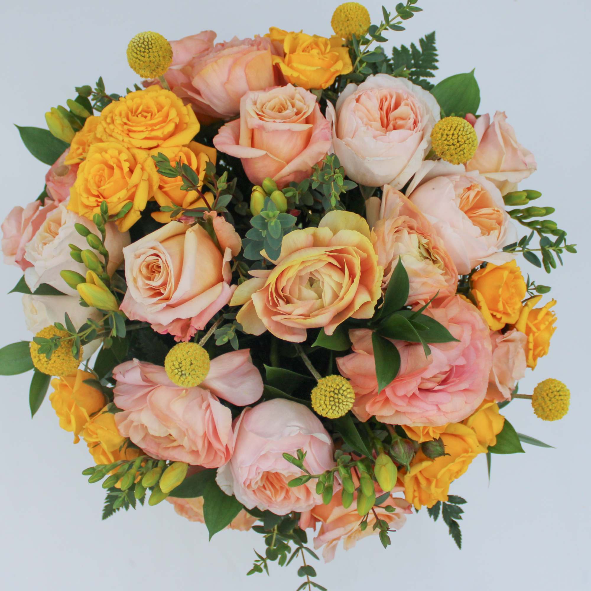 Bouquet of peach and yellow roses with small yellow pom-pom flowers