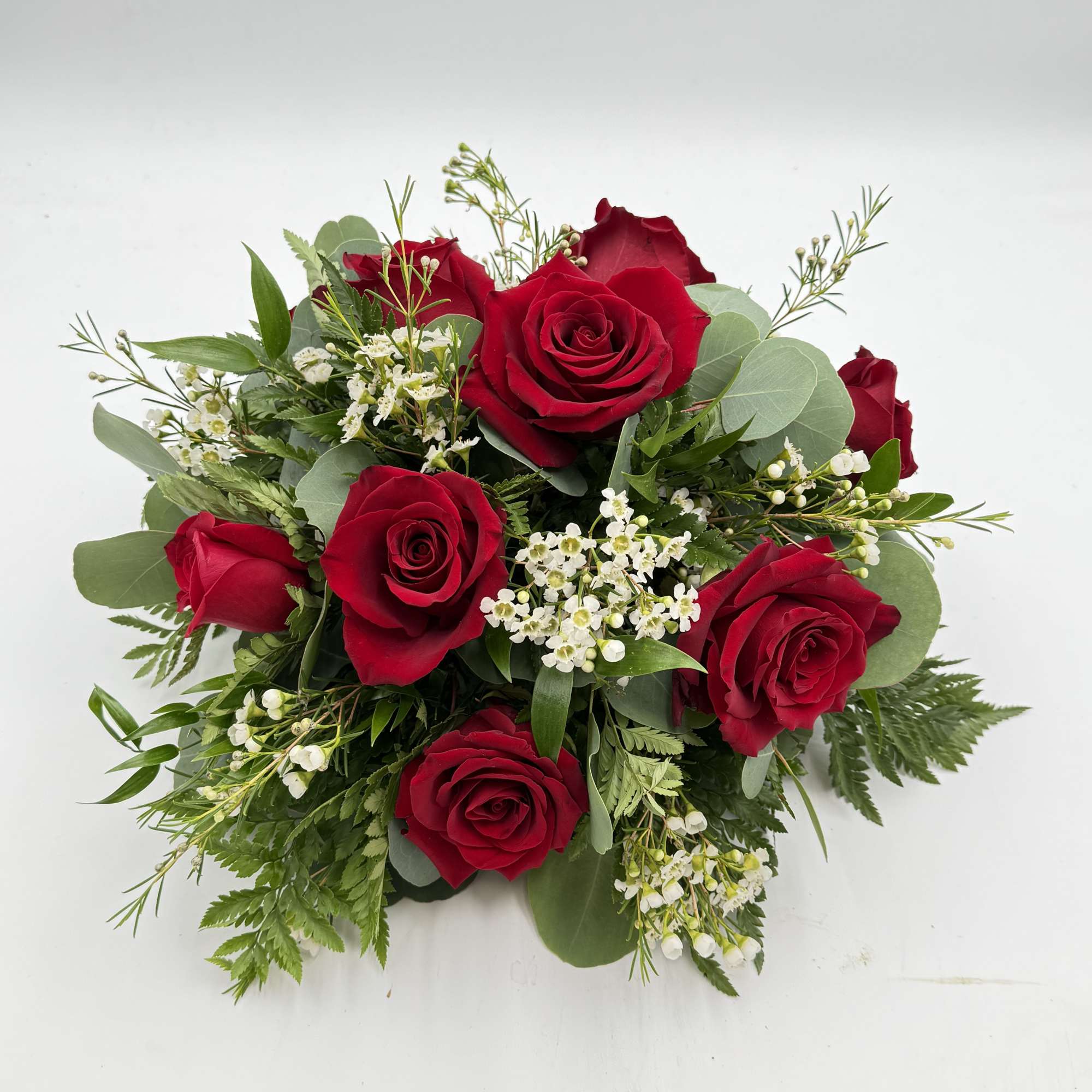 Deep clusters of deep red roses form the heart of this low