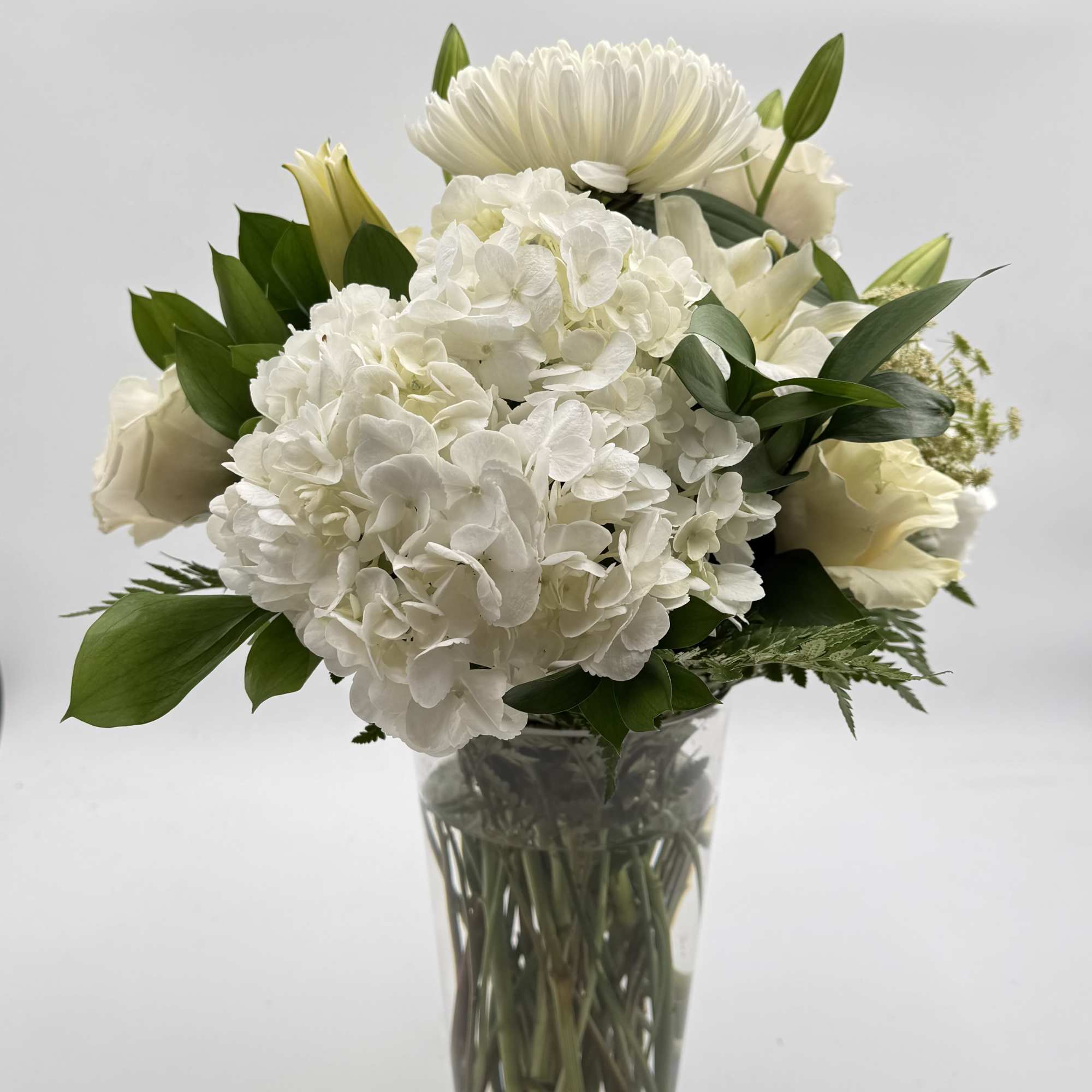 A quiet, composed centerpiece built around a dense cluster of white hydrangeas