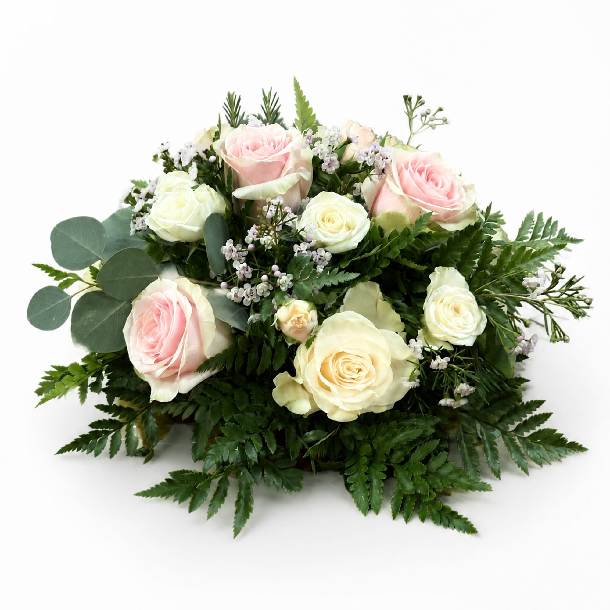 Pink and white roses arranged with greenery on a white background