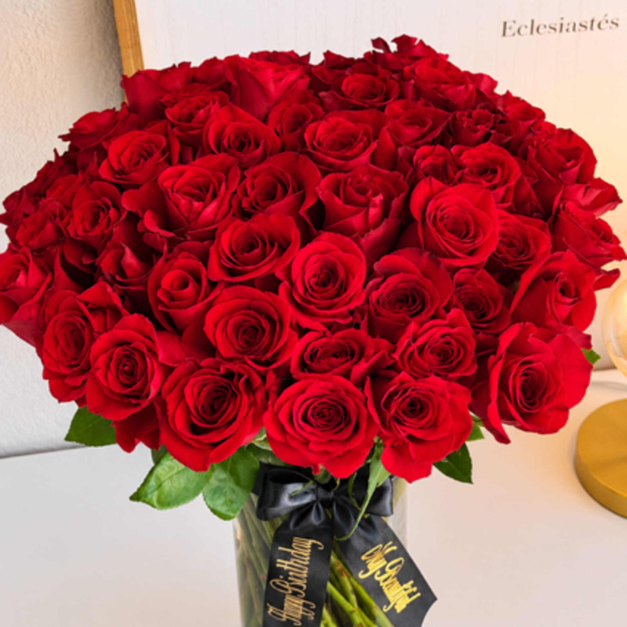 Bouquet of red roses in a glass vase with a black ribbon