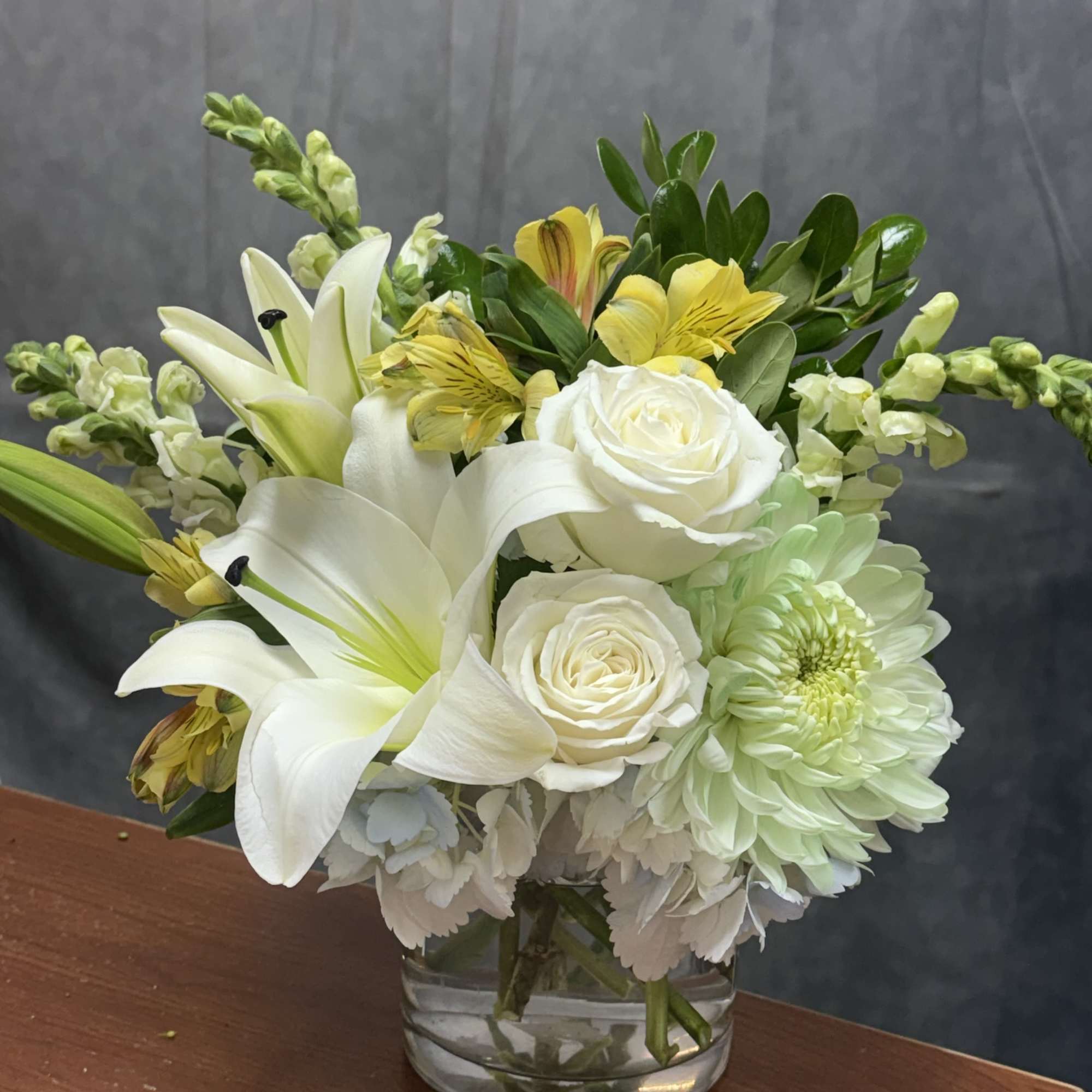 A graceful arrangement blending soft blue hydrangeas, elegant white lilies, creamy white