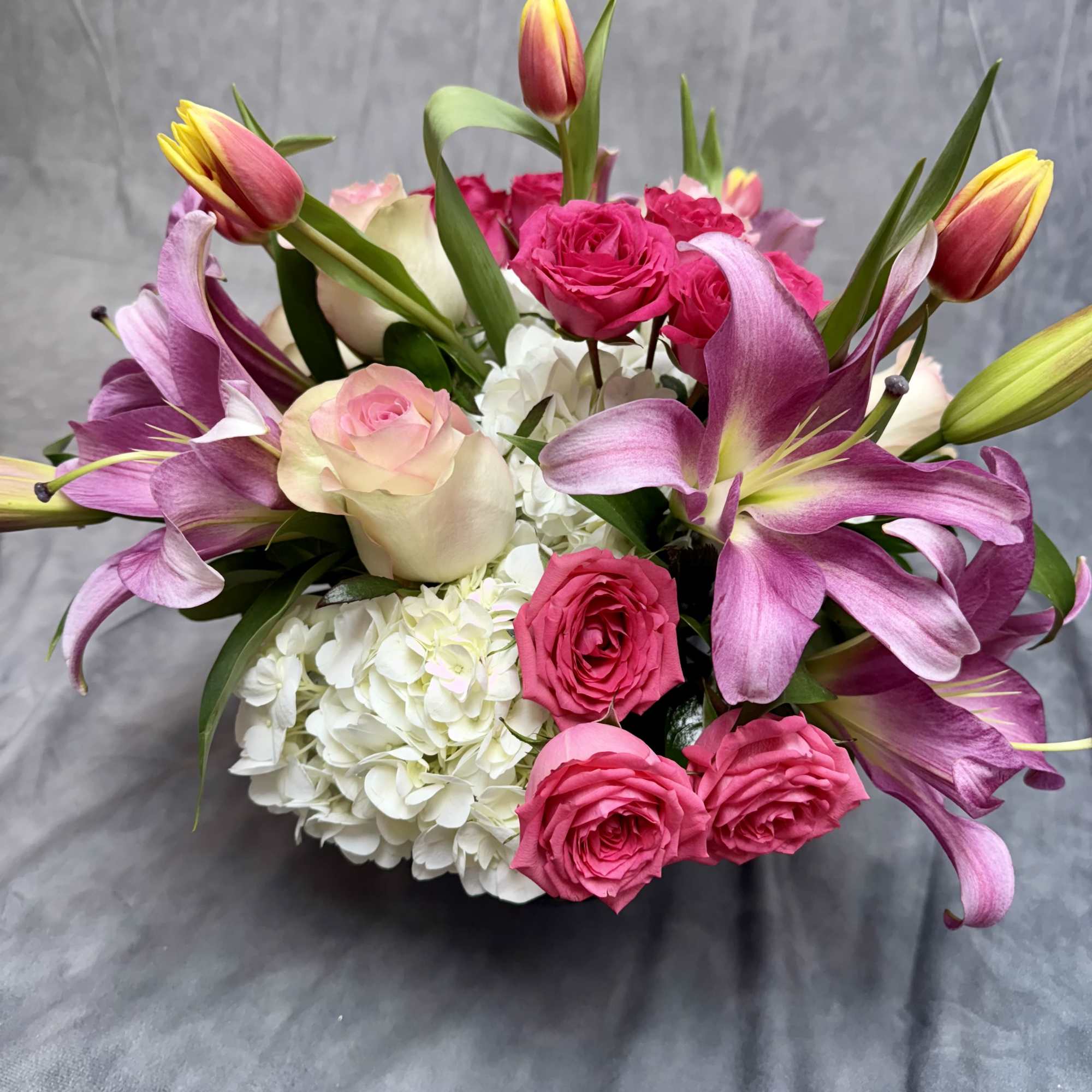 Bouquet of pink roses, purple lilies, and white hydrangea