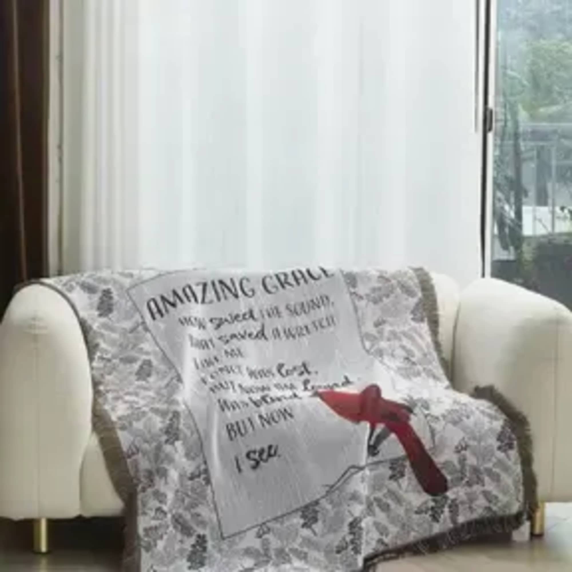 Quilted throw blanket draped over a sofa with a red ribbon bow
