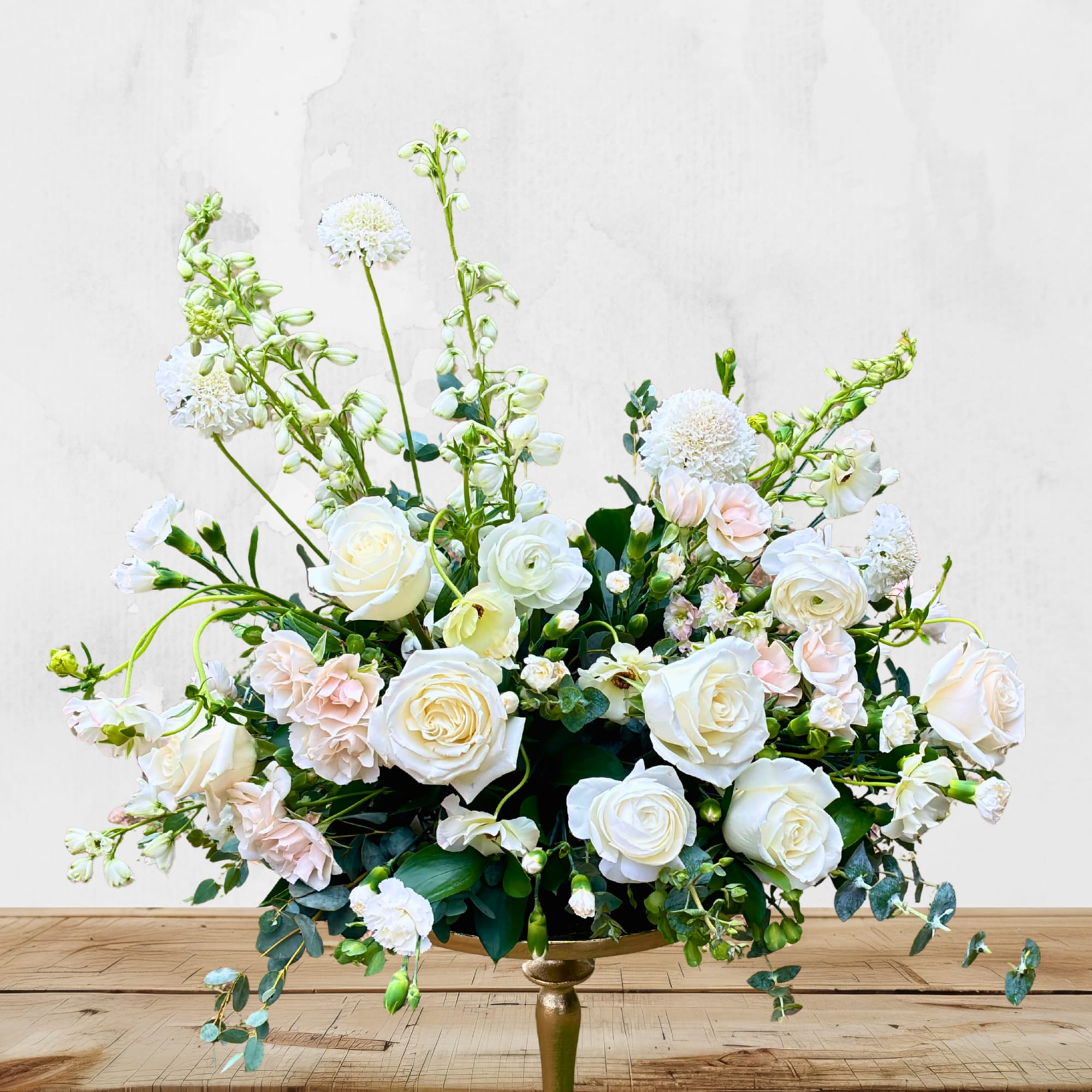 White and blush floral arrangement in a gold pedestal vase