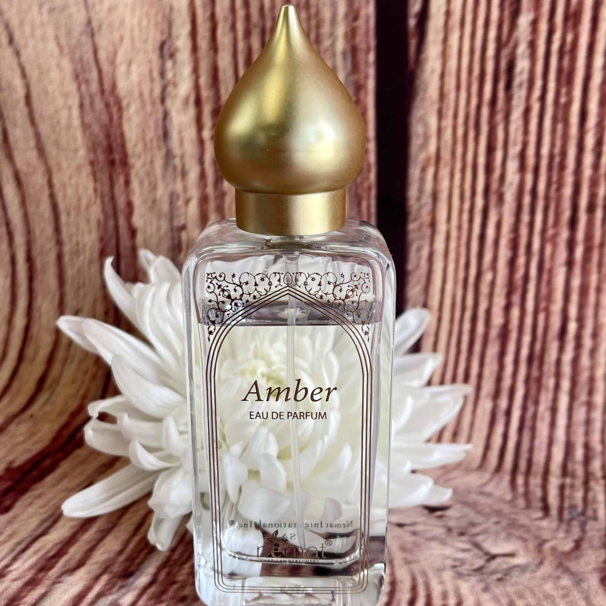 Perfume bottle with white flowers behind it