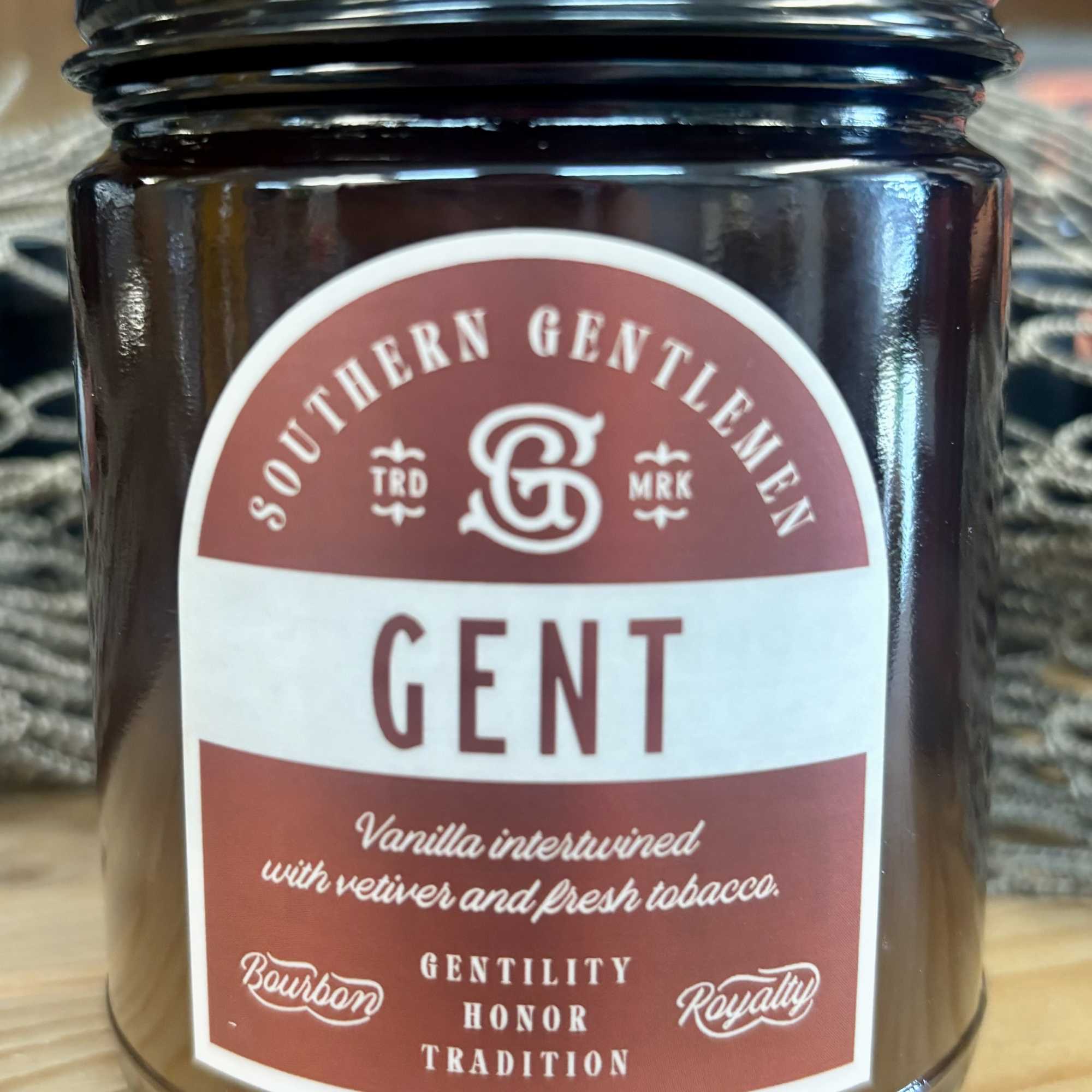 Brown candle jar with a black lid and labeled "GENT"