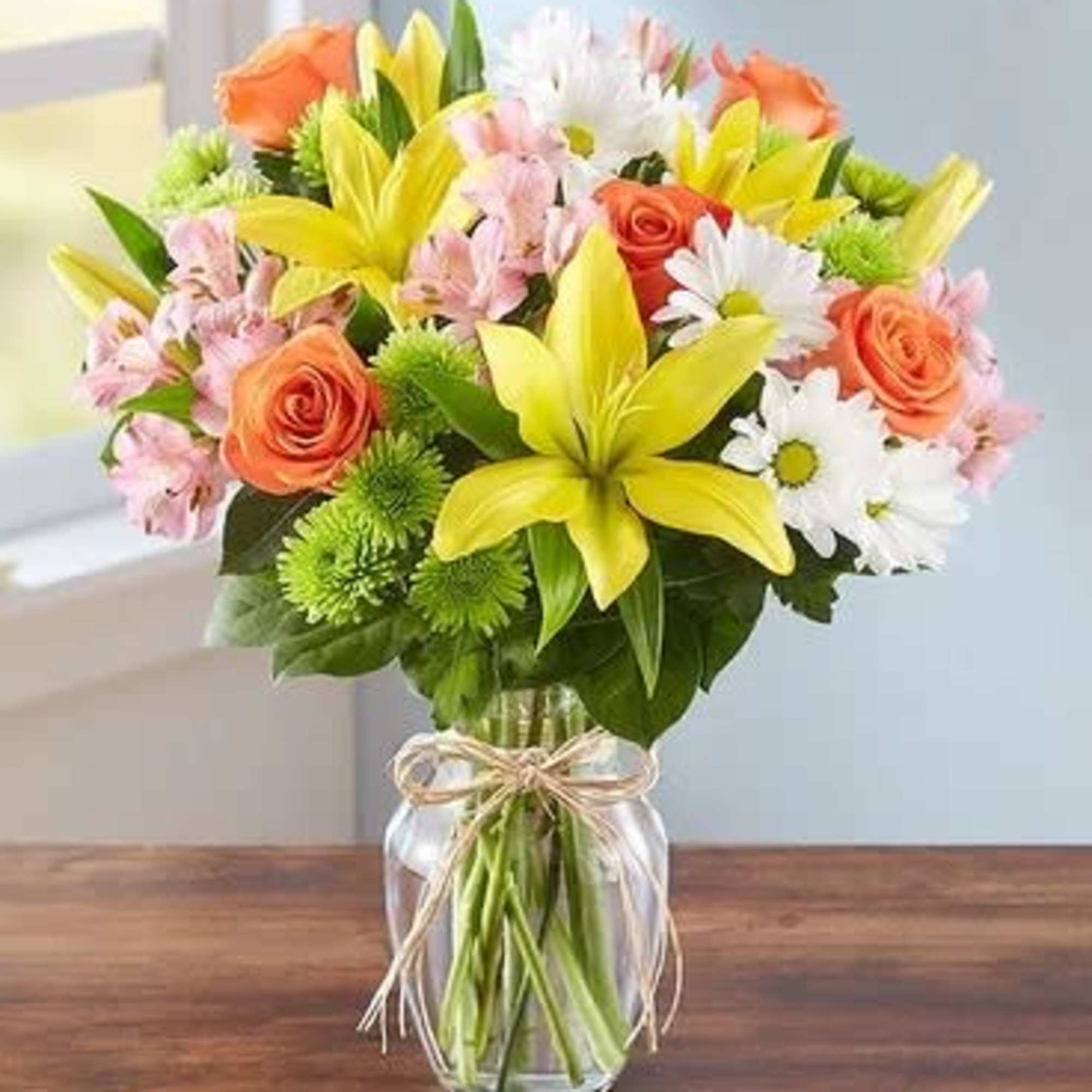 Bouquet of yellow lilies, orange roses, and white daisies in a glass vase, photo 3 of 3