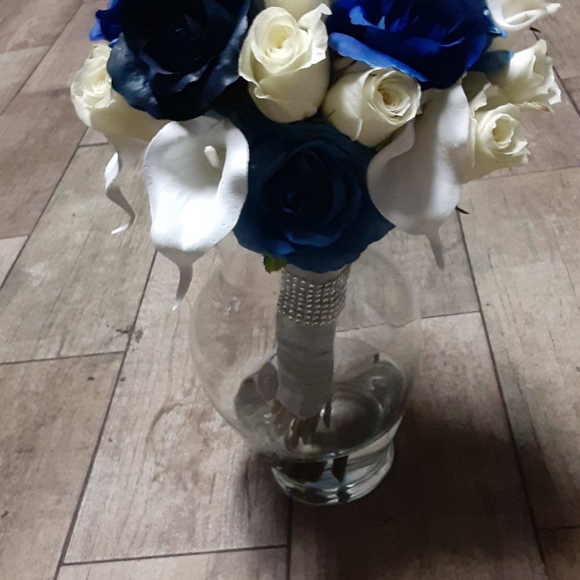 Bouquet of blue, white, and cream roses in a glass vase