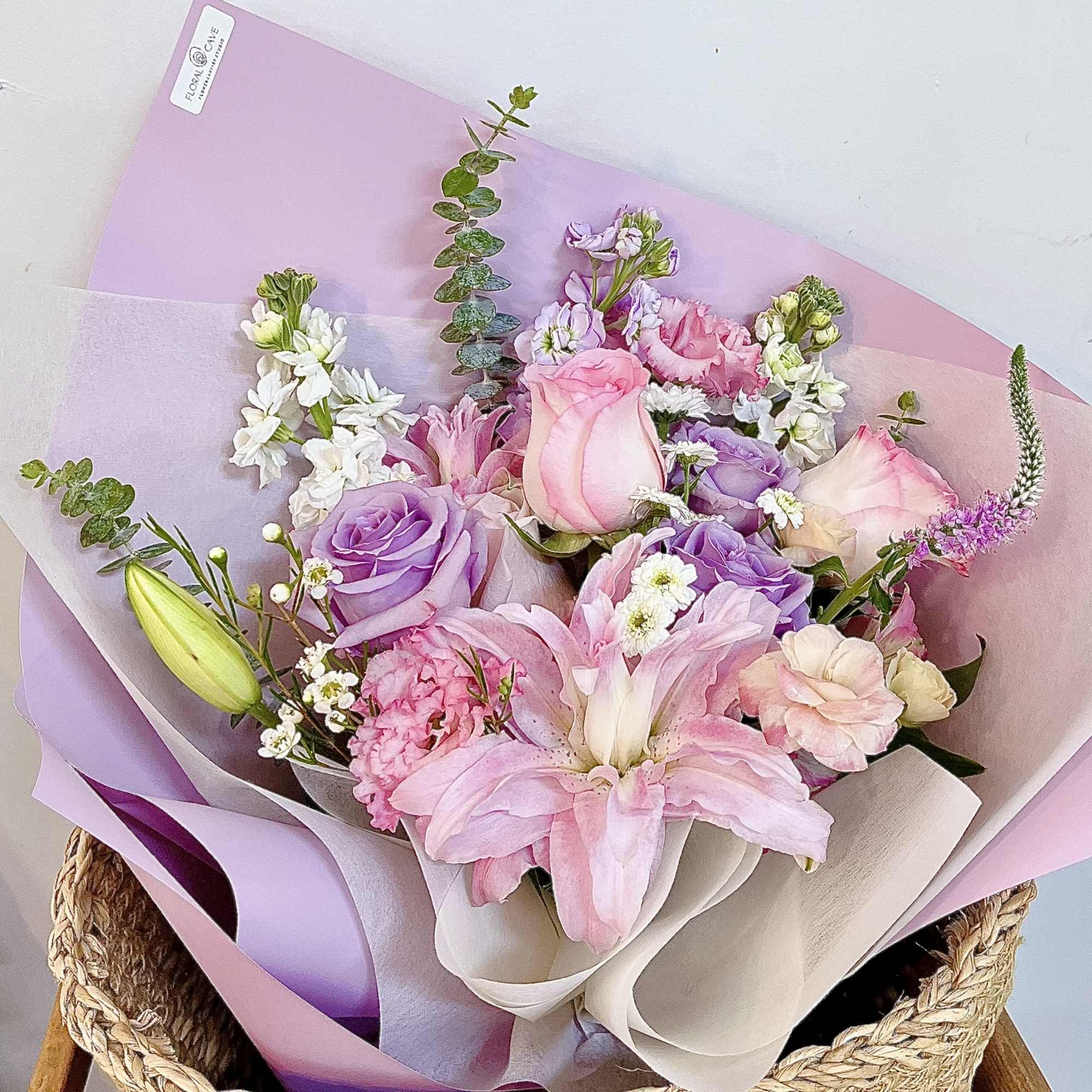 Pink and lavender bouquet with roses, lilies, and white accent flowers