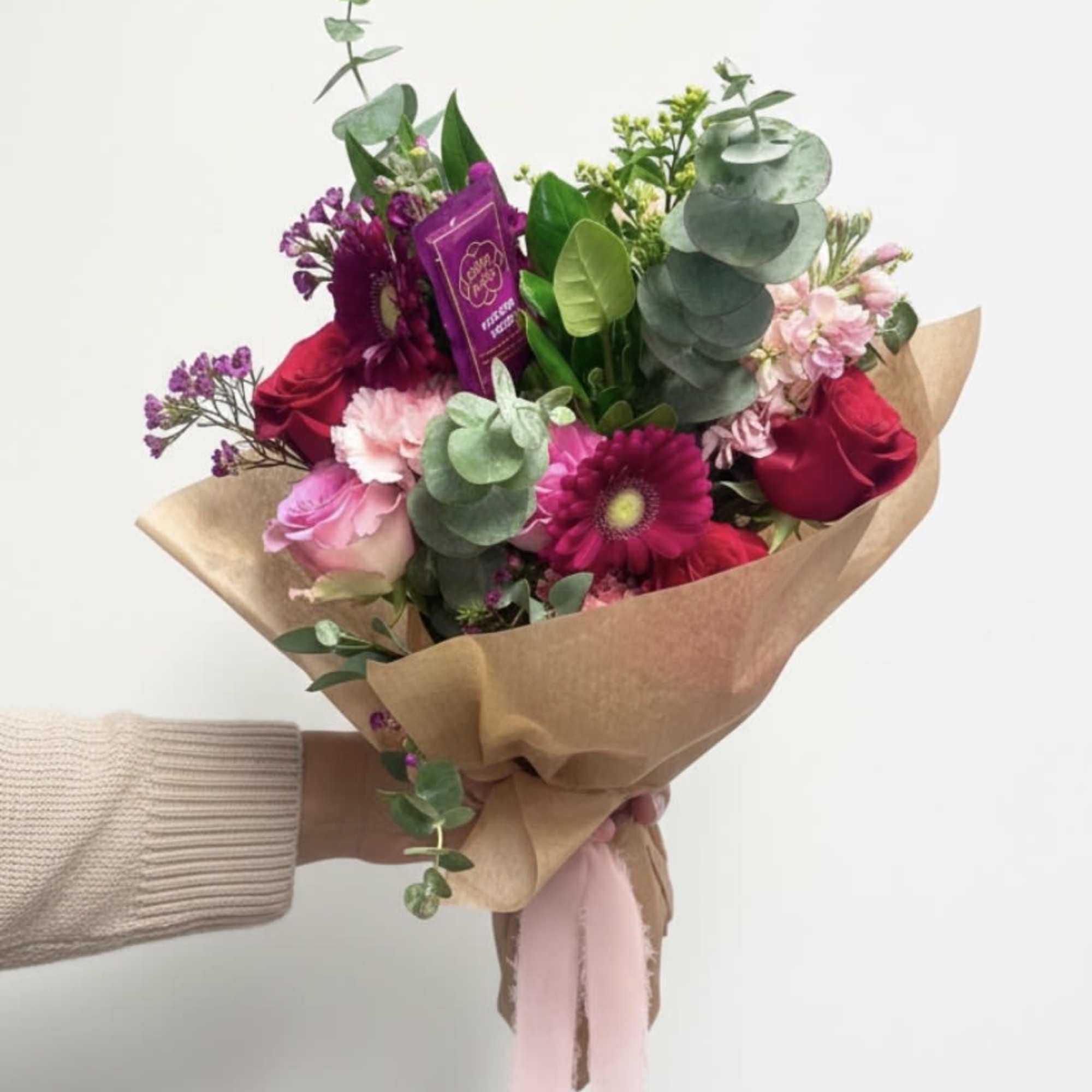 A soft and romantic hand-tied bouquet designed with fresh seasonal blooms in, photo 2 of 2