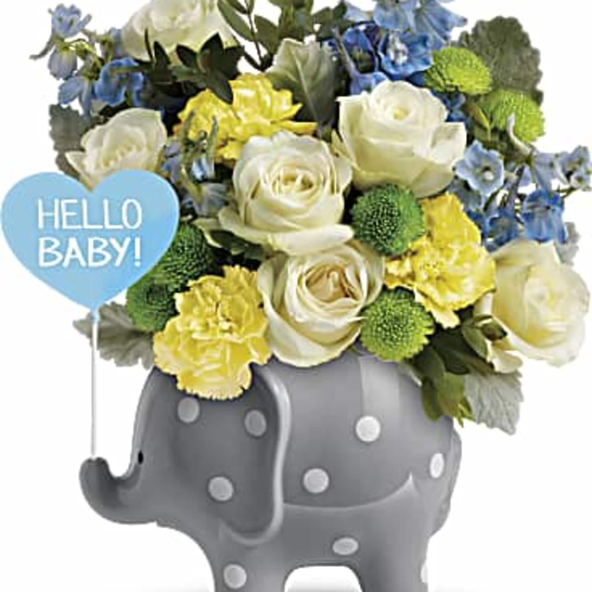 Bouquet of white, yellow, and blue flowers in a gray elephant vase with a baby sign