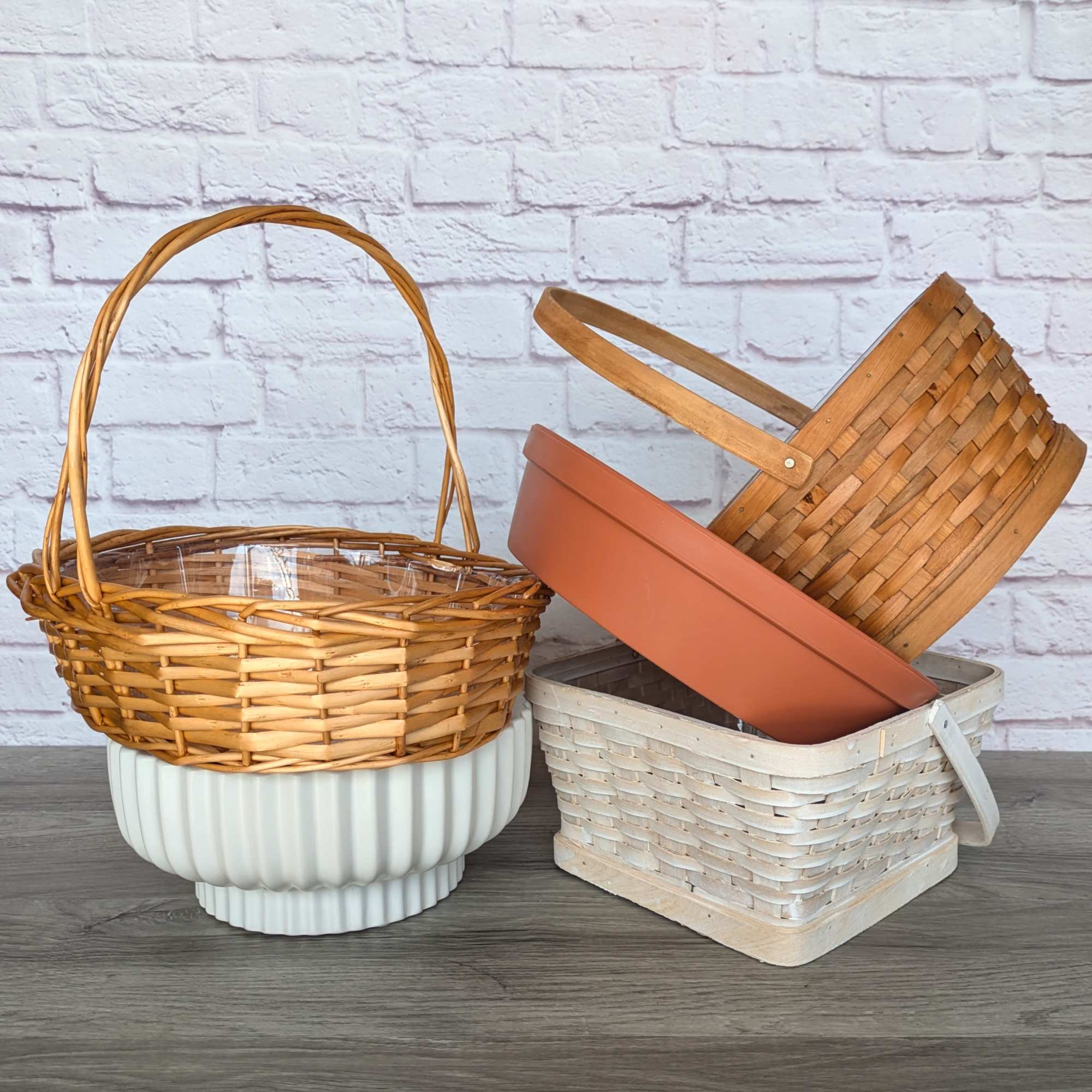 Three empty baskets and a planter on a wooden surface