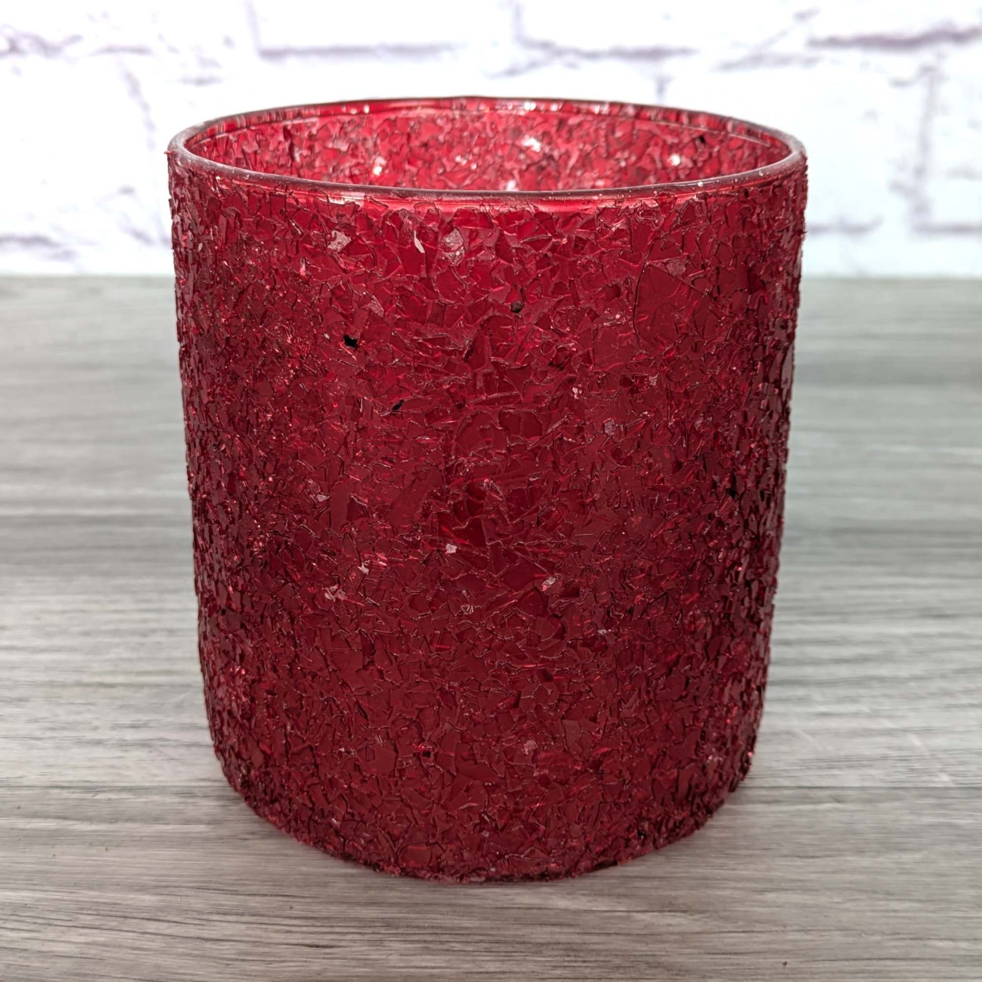Red textured glass candle holder on a tabletop