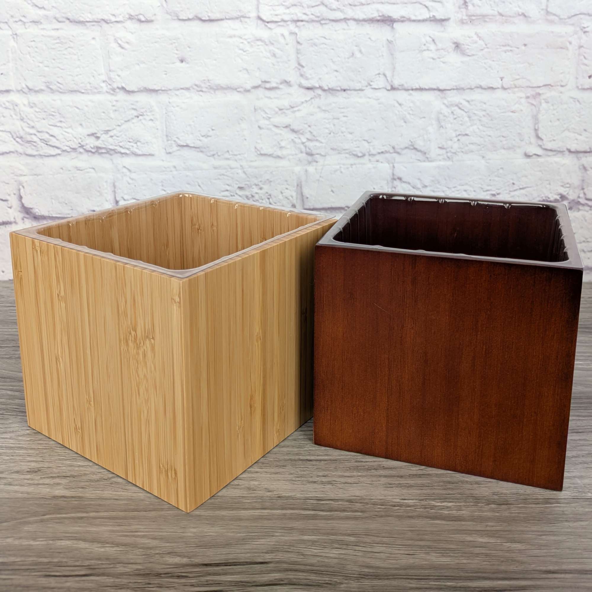 Two square wooden planters sit side by side on a tabletop.