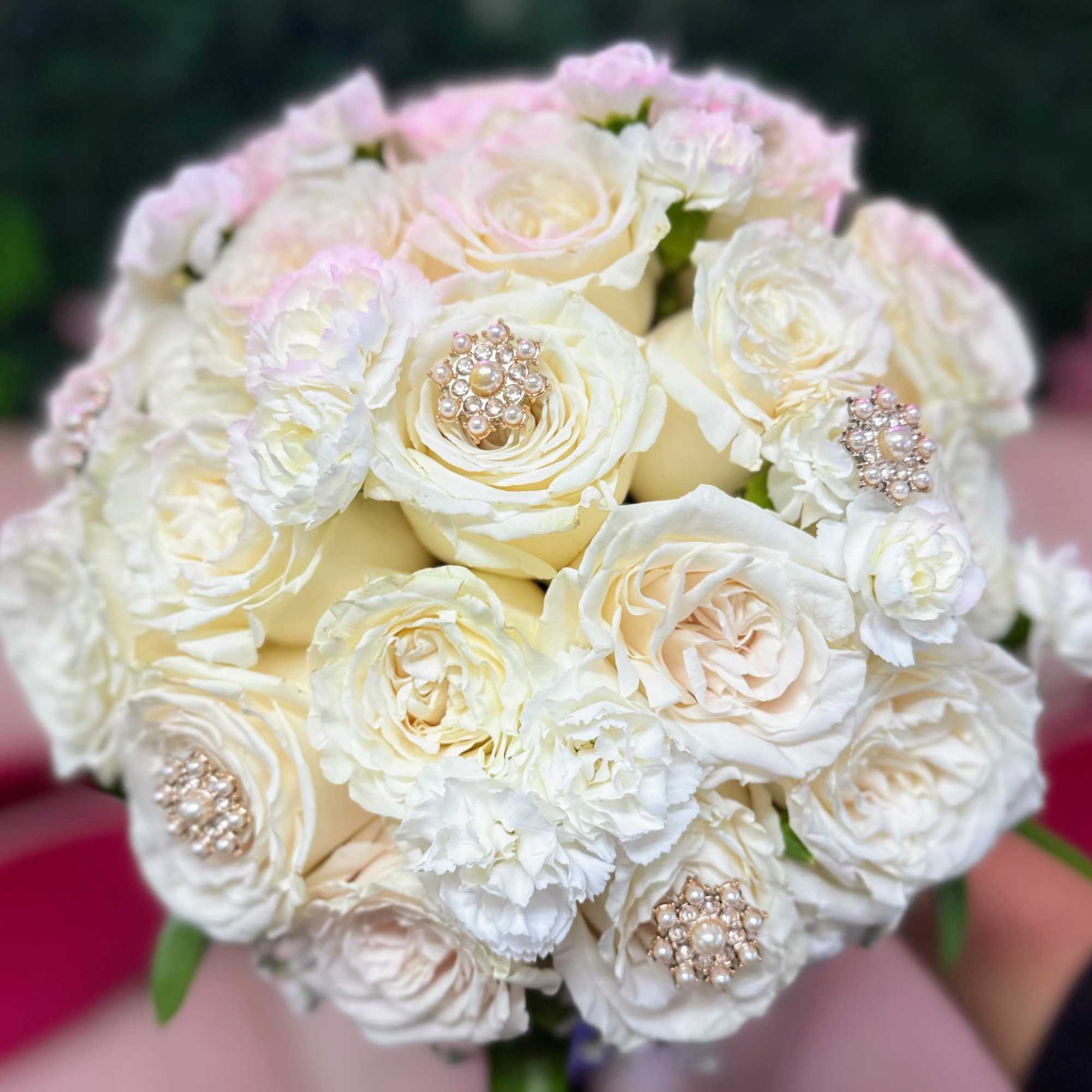 Round bouquet of white roses and carnations with jeweled accents