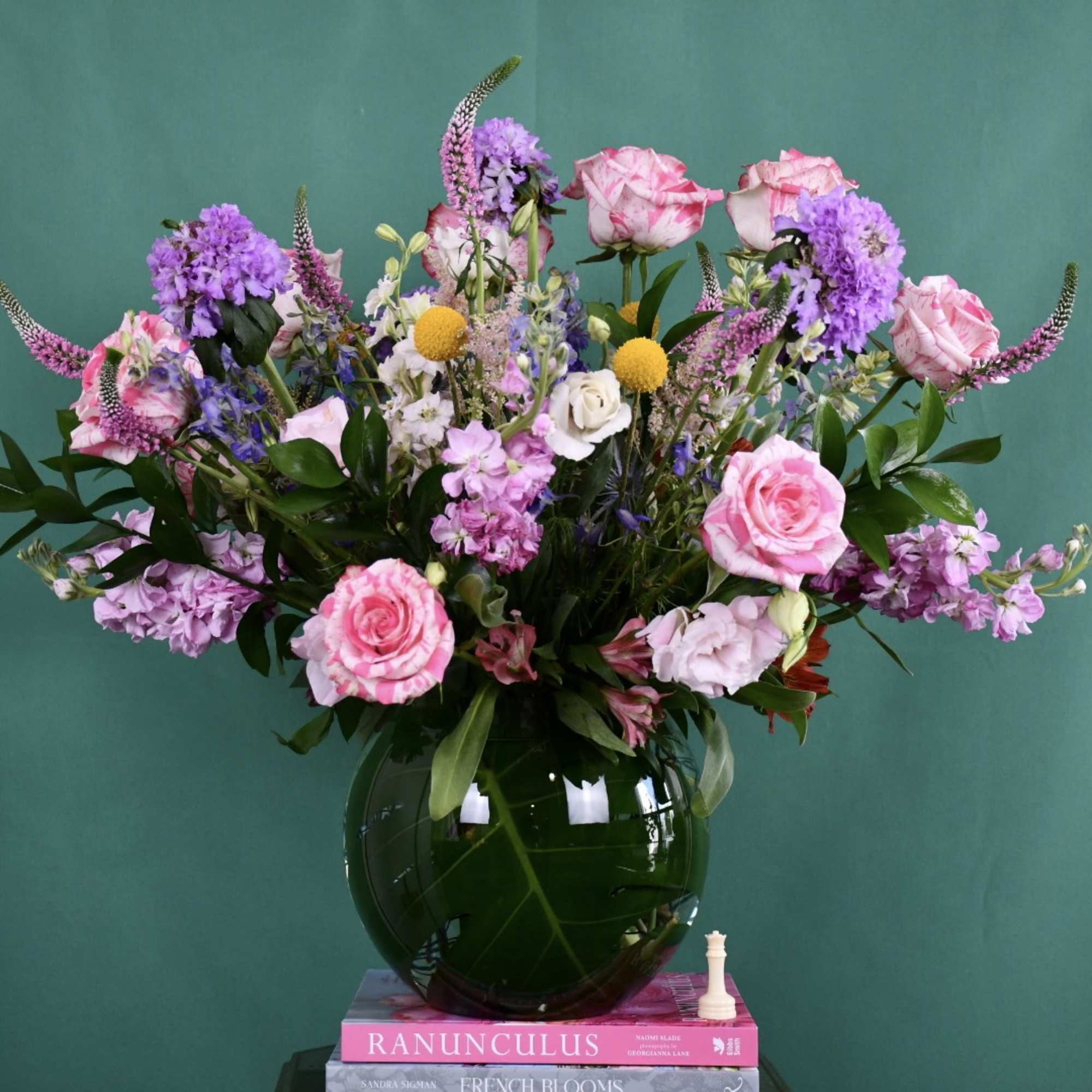 Pink and purple mixed bouquet in a dark glass vase