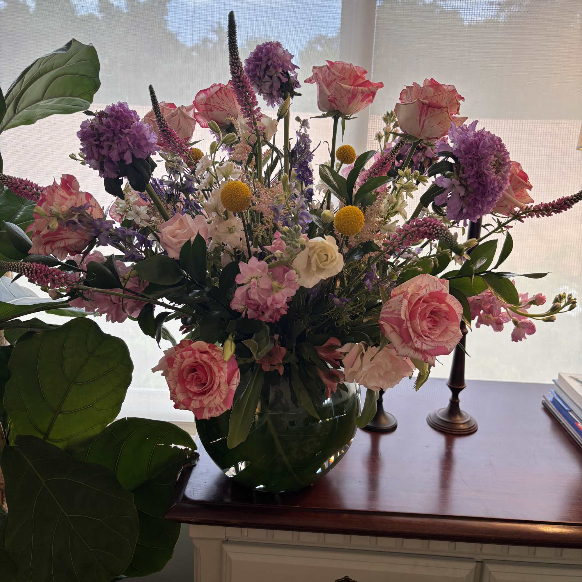 Large mixed bouquet in a glass vase with pink roses and purple blooms