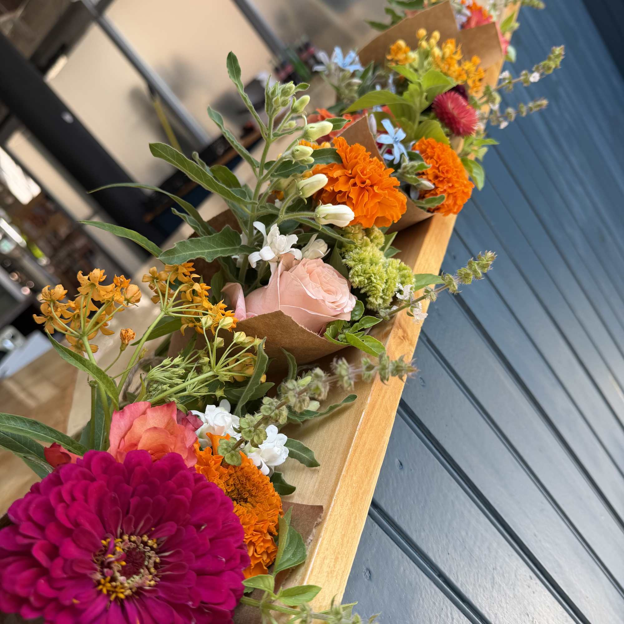 Colorful flower bouquets wrapped in brown paper on a bench