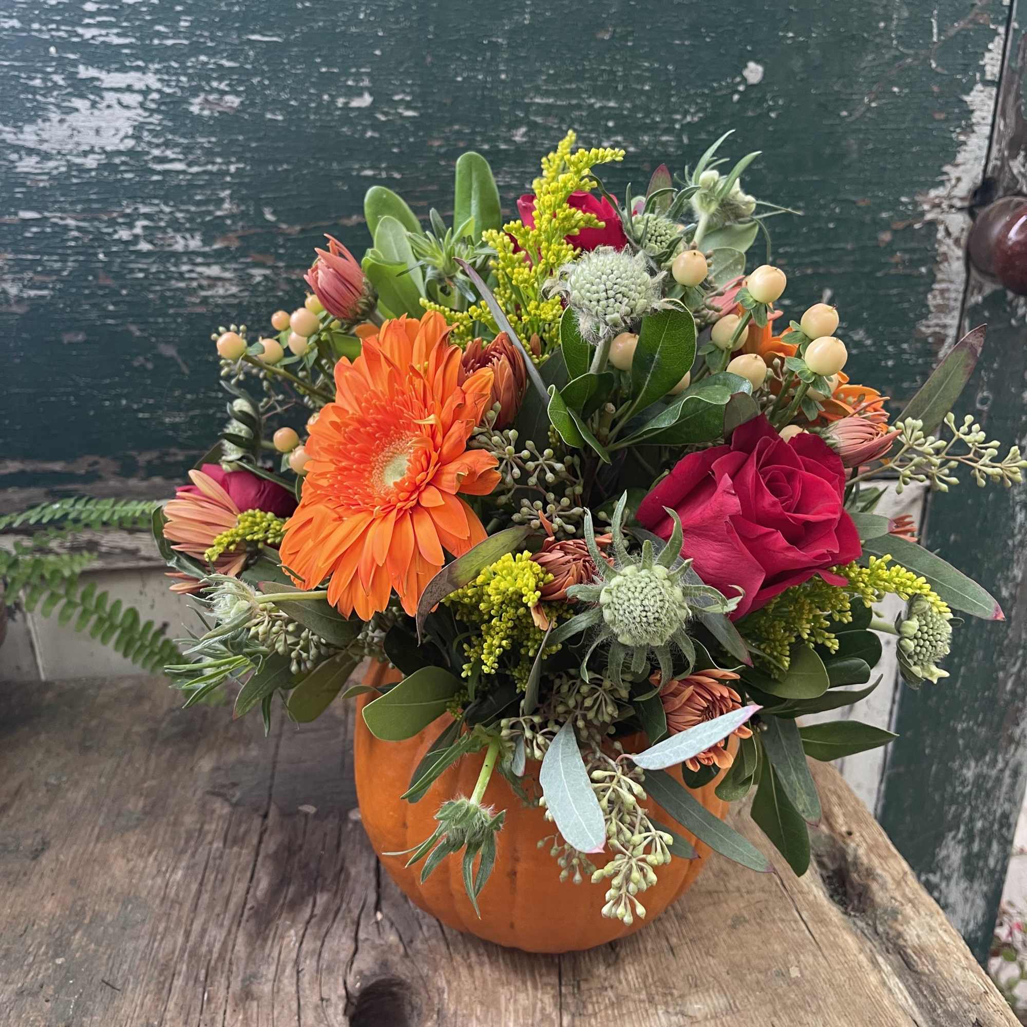 Orange and pink mixed bouquet in a pumpkin-shaped container