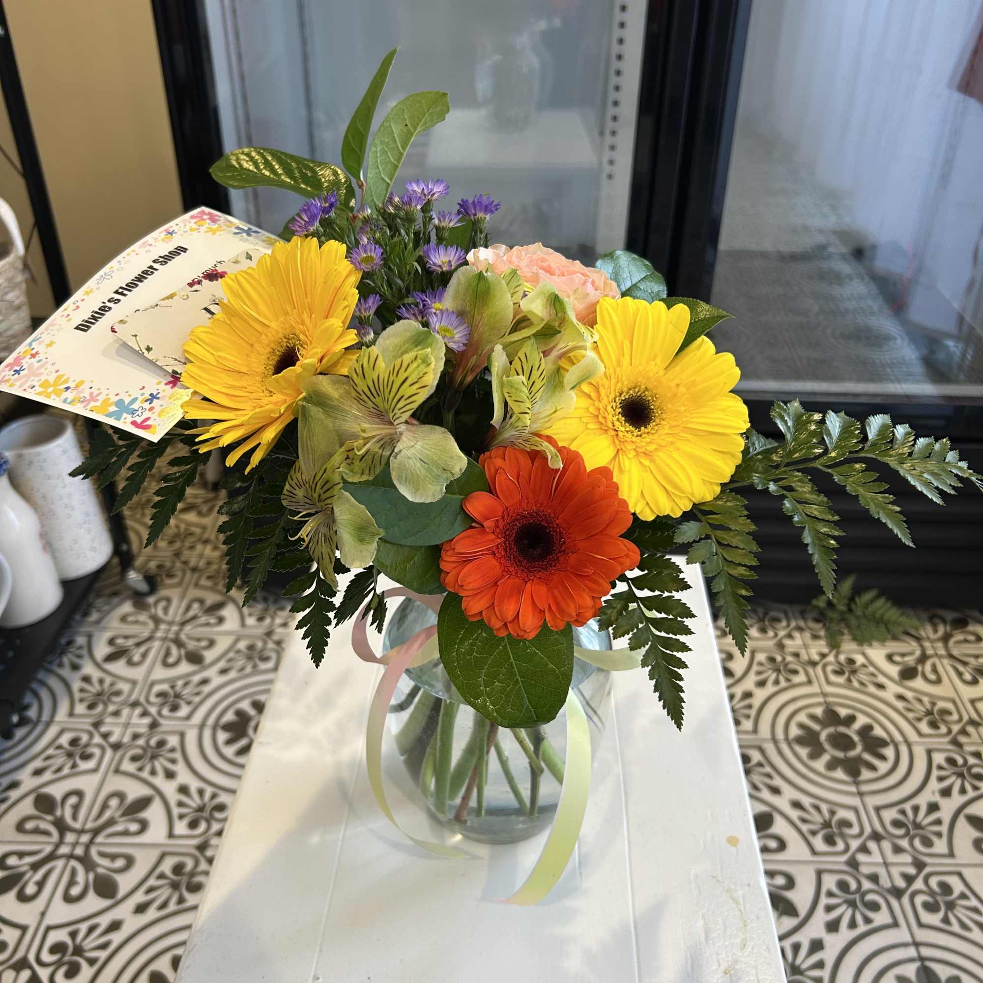 Mixed bouquet with yellow and orange gerbera daisies in a glass vase