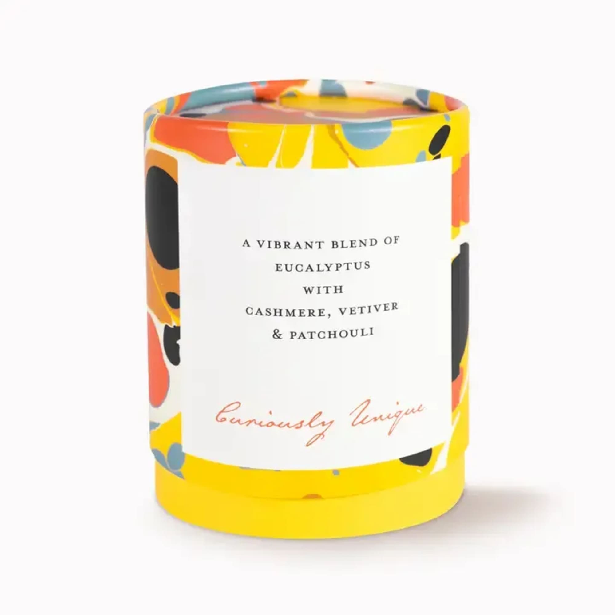 Colorful scented candle in a patterned glass jar