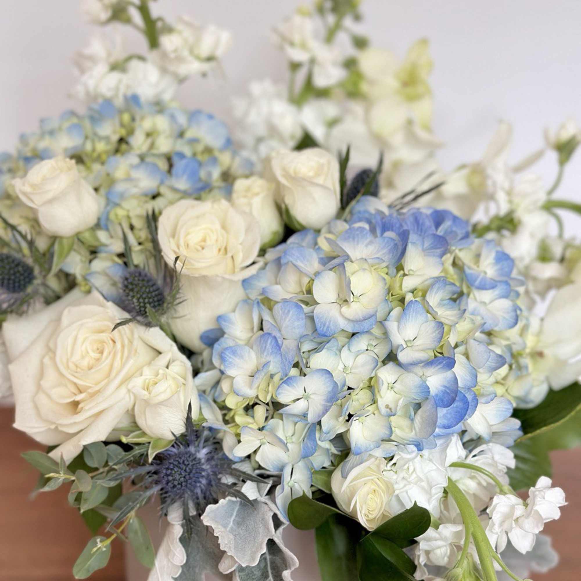 Bouquet of white roses and blue hydrangeas with white flowers