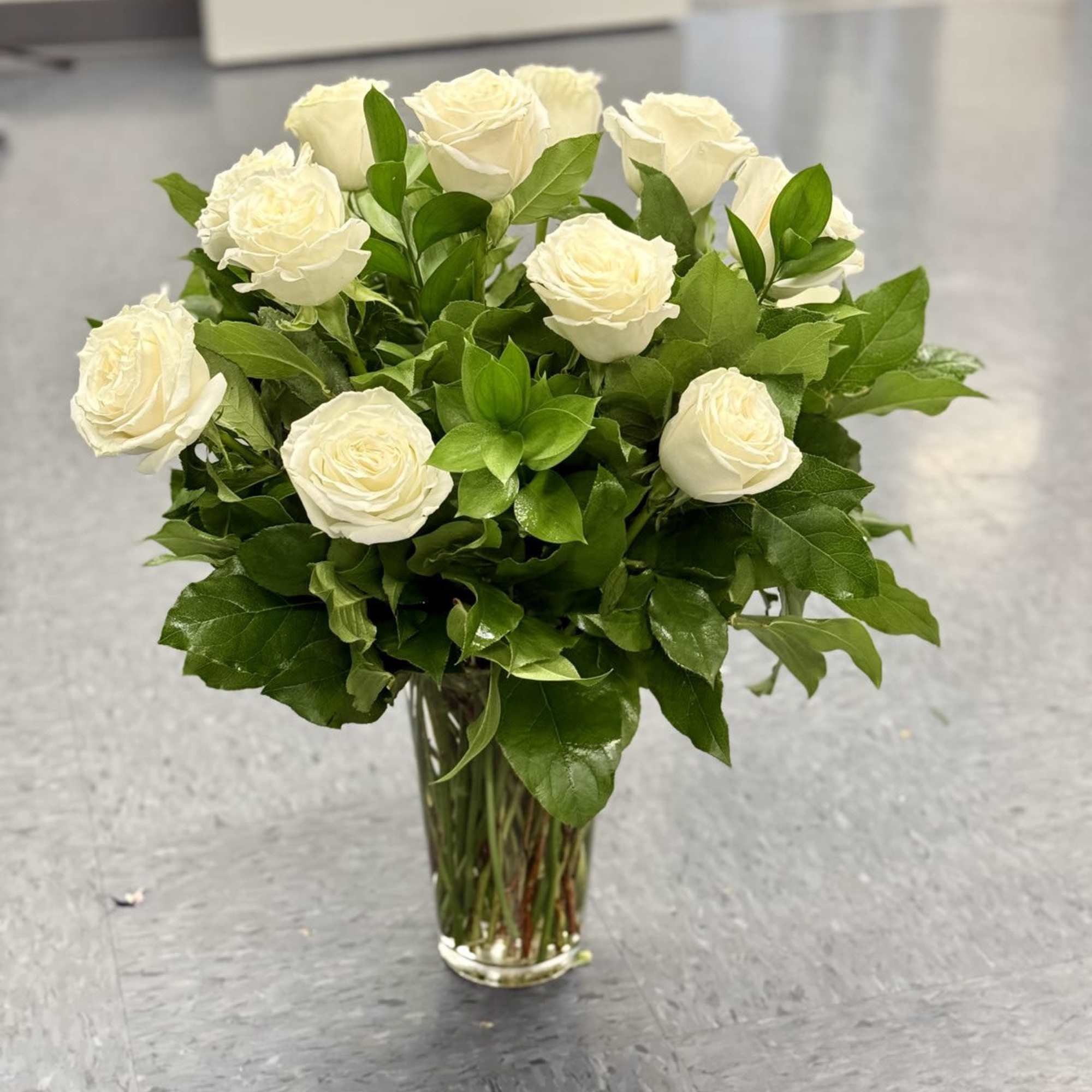 White roses arranged in a clear glass vase