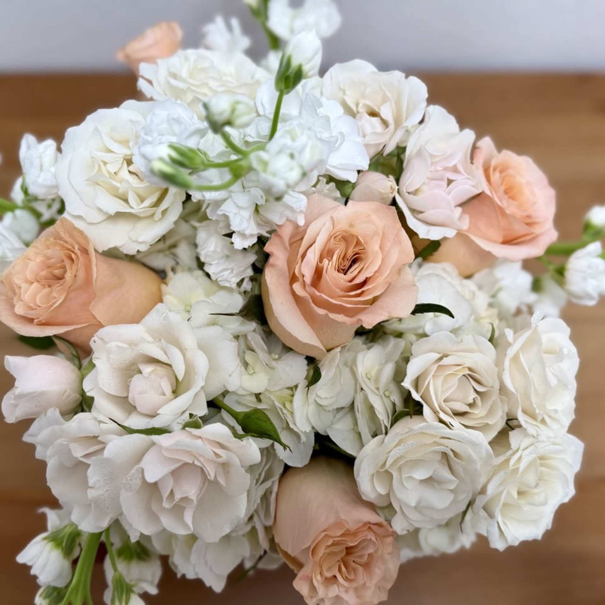 Bouquet of peach and white roses with white filler flowers