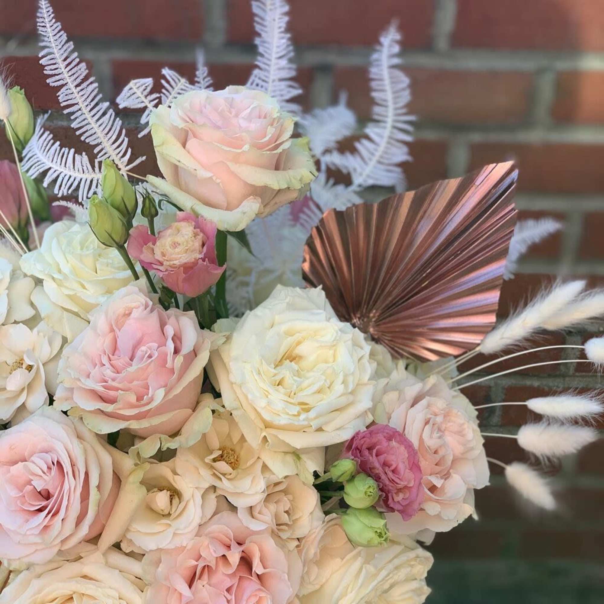 Bouquet of pale pink and white roses with decorative feathers
