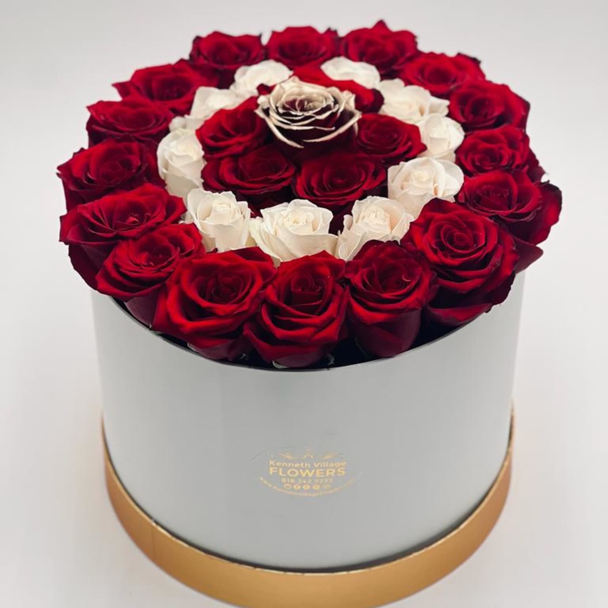 Round box arrangement of red and white roses