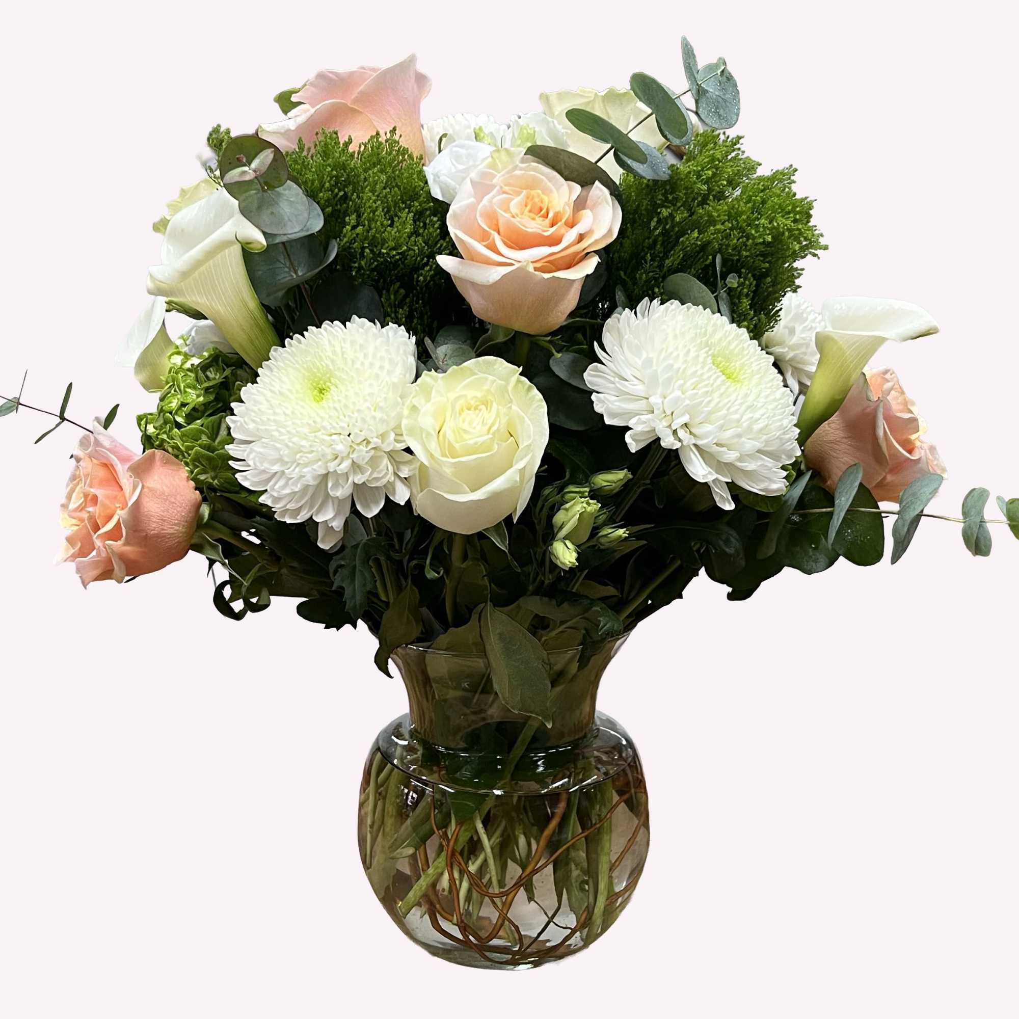 Bouquet of peach and white roses with white mums in a glass vase