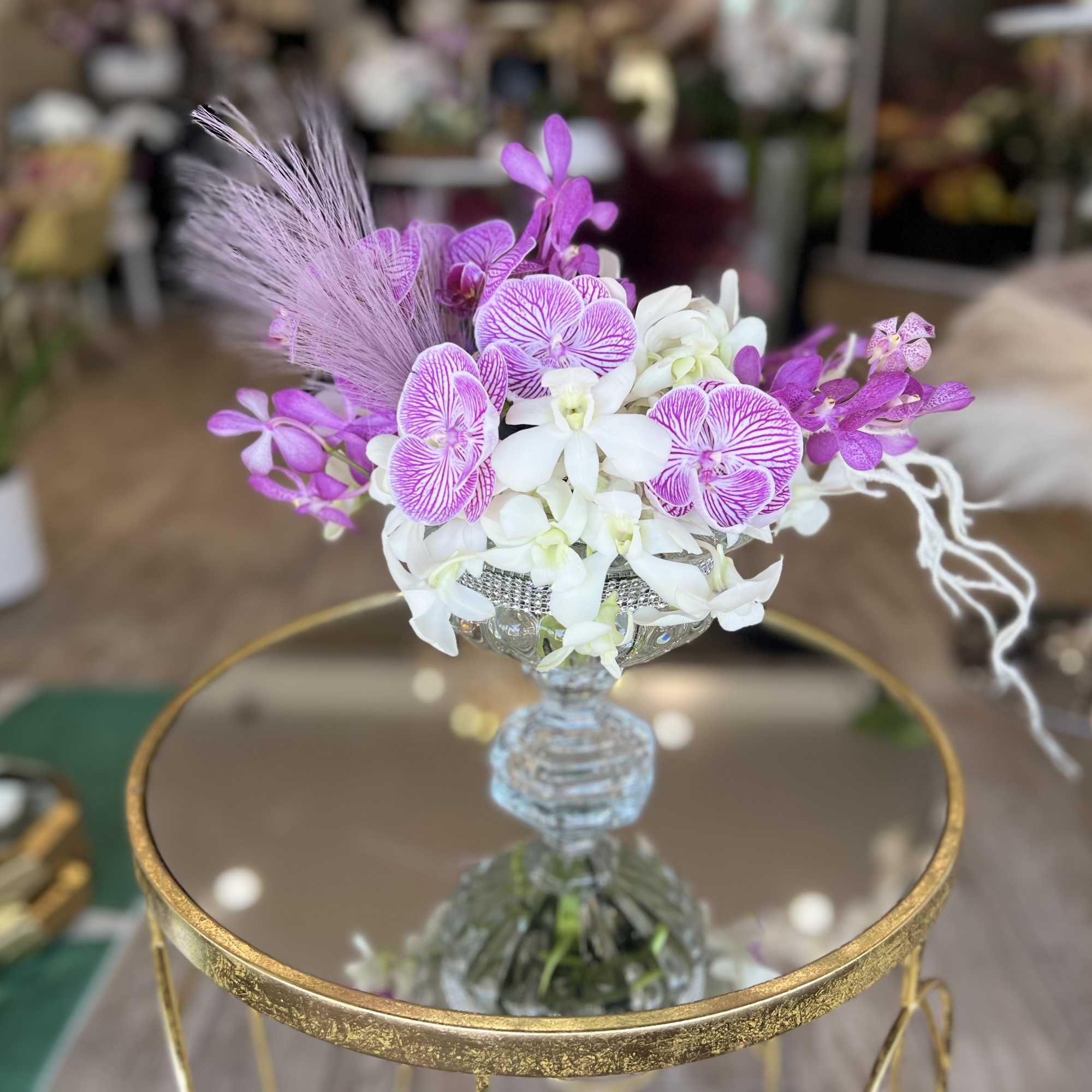 Purple and white orchid arrangement in a glass vase