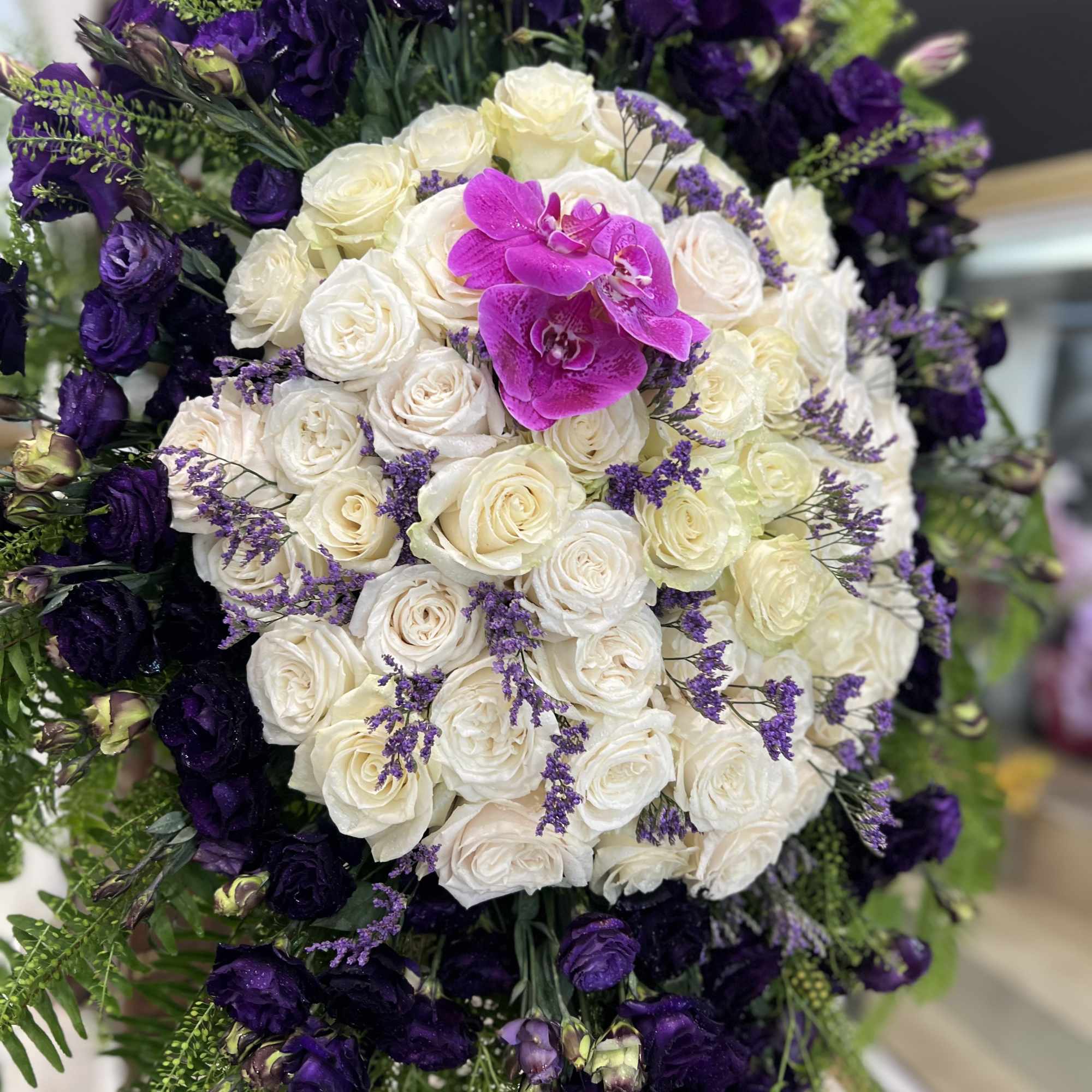 White and purple rose arrangement with a bright pink orchid center