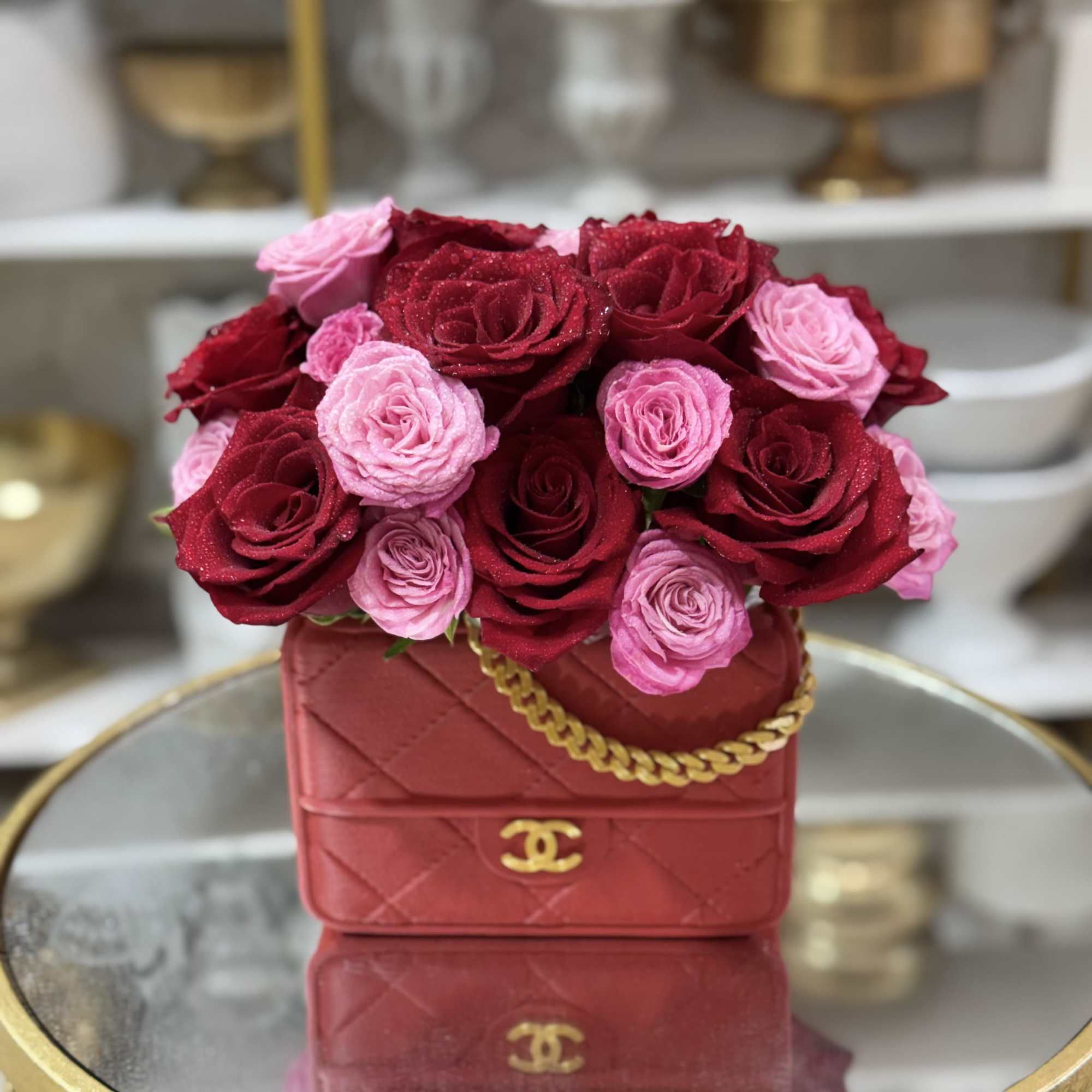 Pink and red roses arranged in a red handbag-shaped box