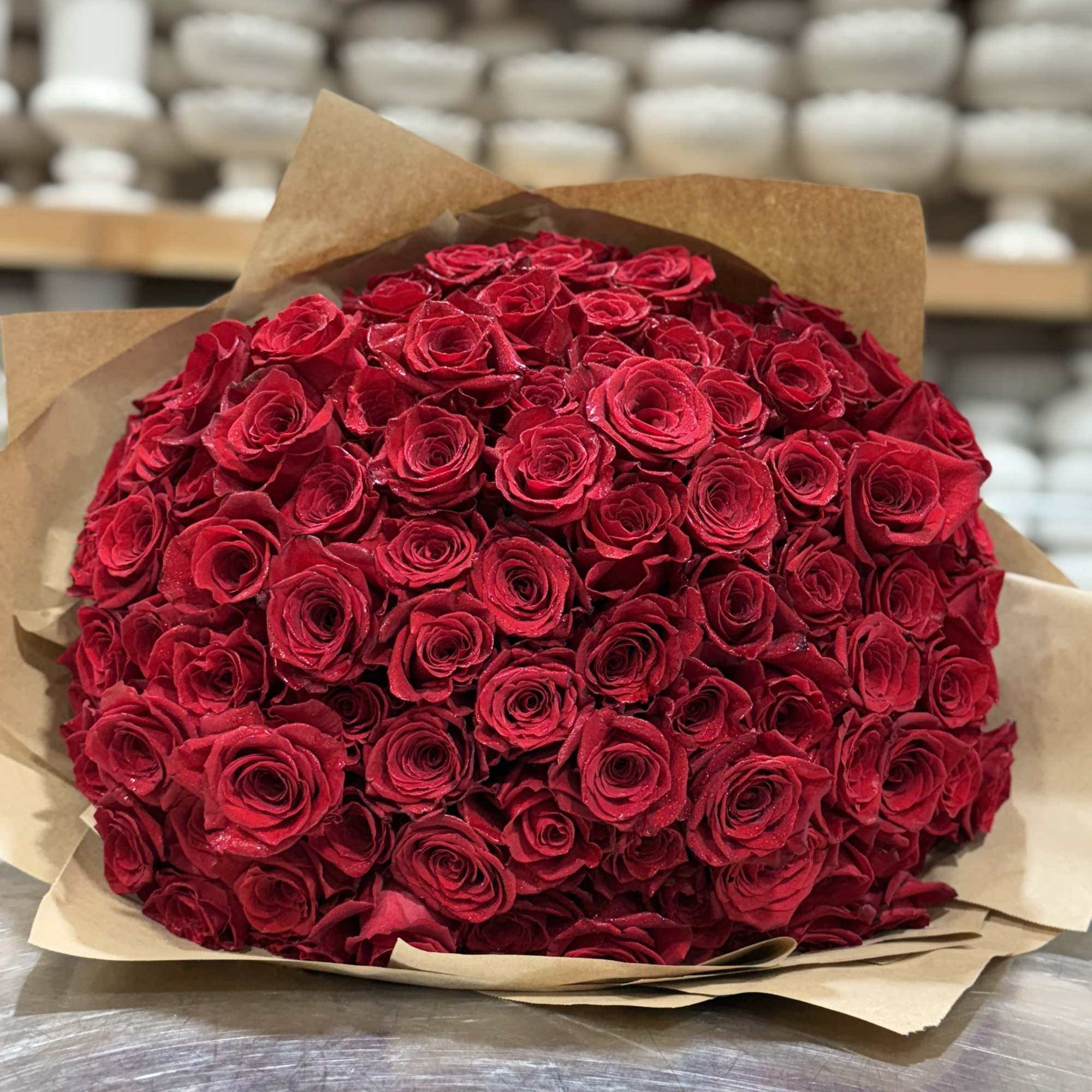 Large bouquet of red roses wrapped in brown paper