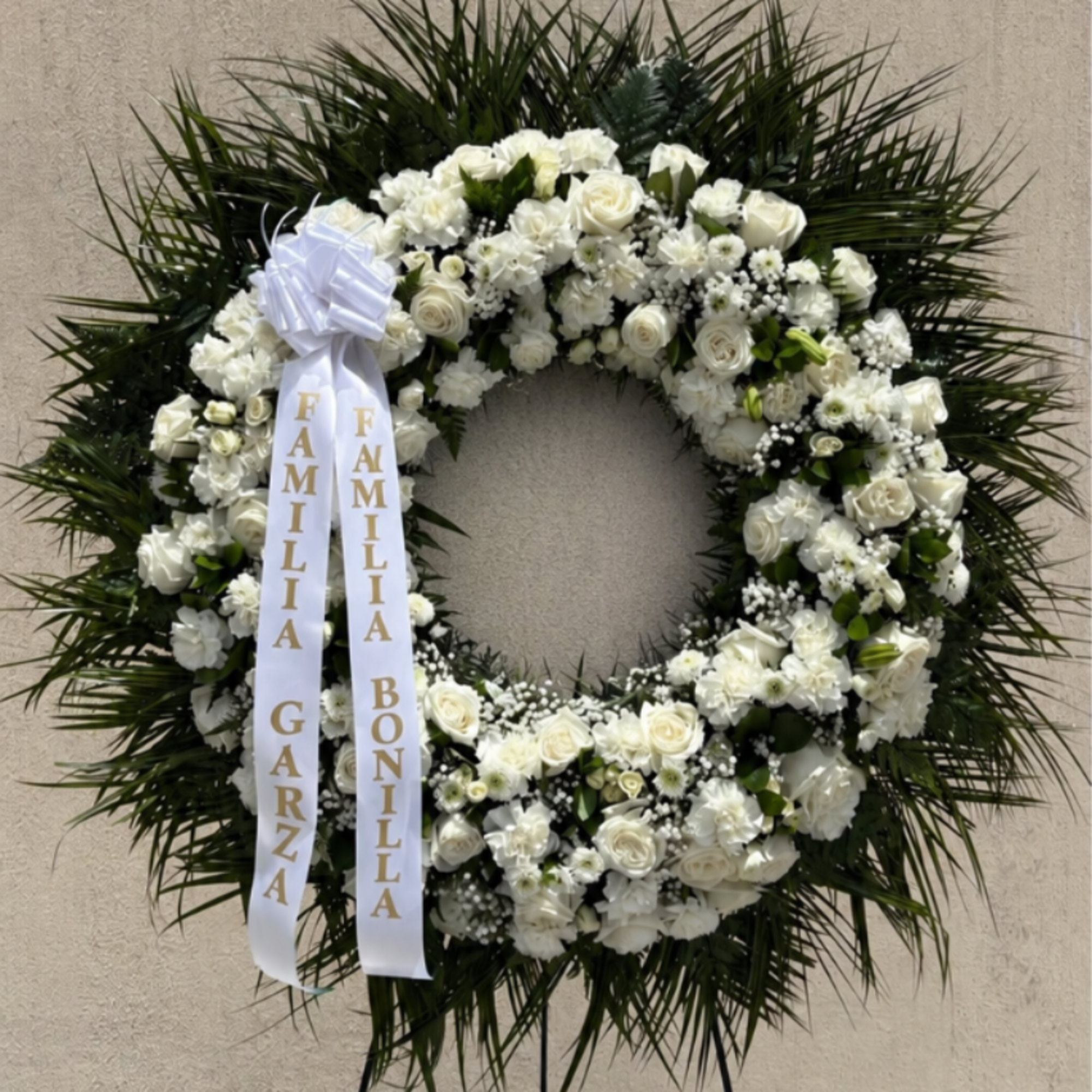 A classic white sympathy wreath that offers a quiet, dignified tribute for