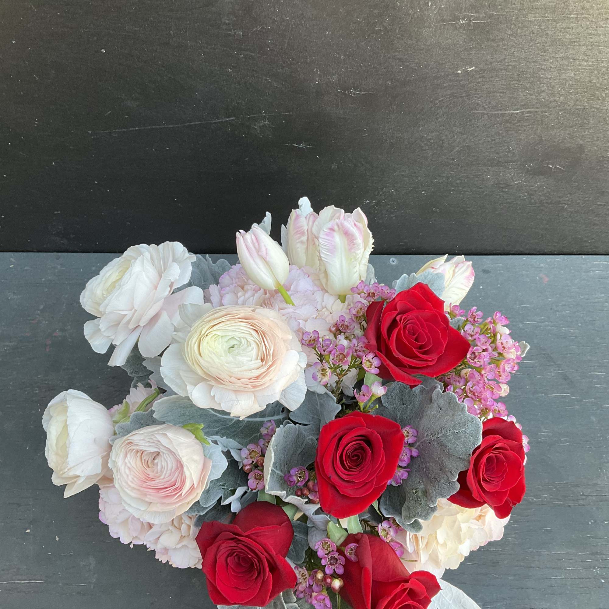 Bouquet of red and pale pink roses with white blooms and silver foliage