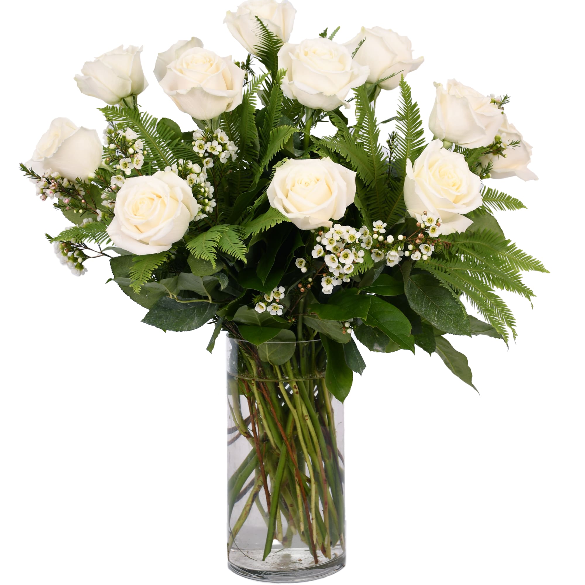White roses arranged in a clear glass vase with fern foliage, photo 2 of 2