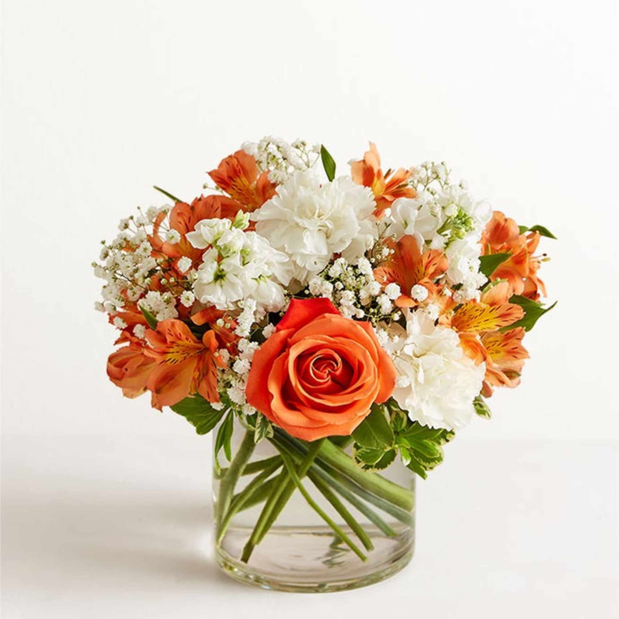 Orange and white flower arrangement in a clear glass vase