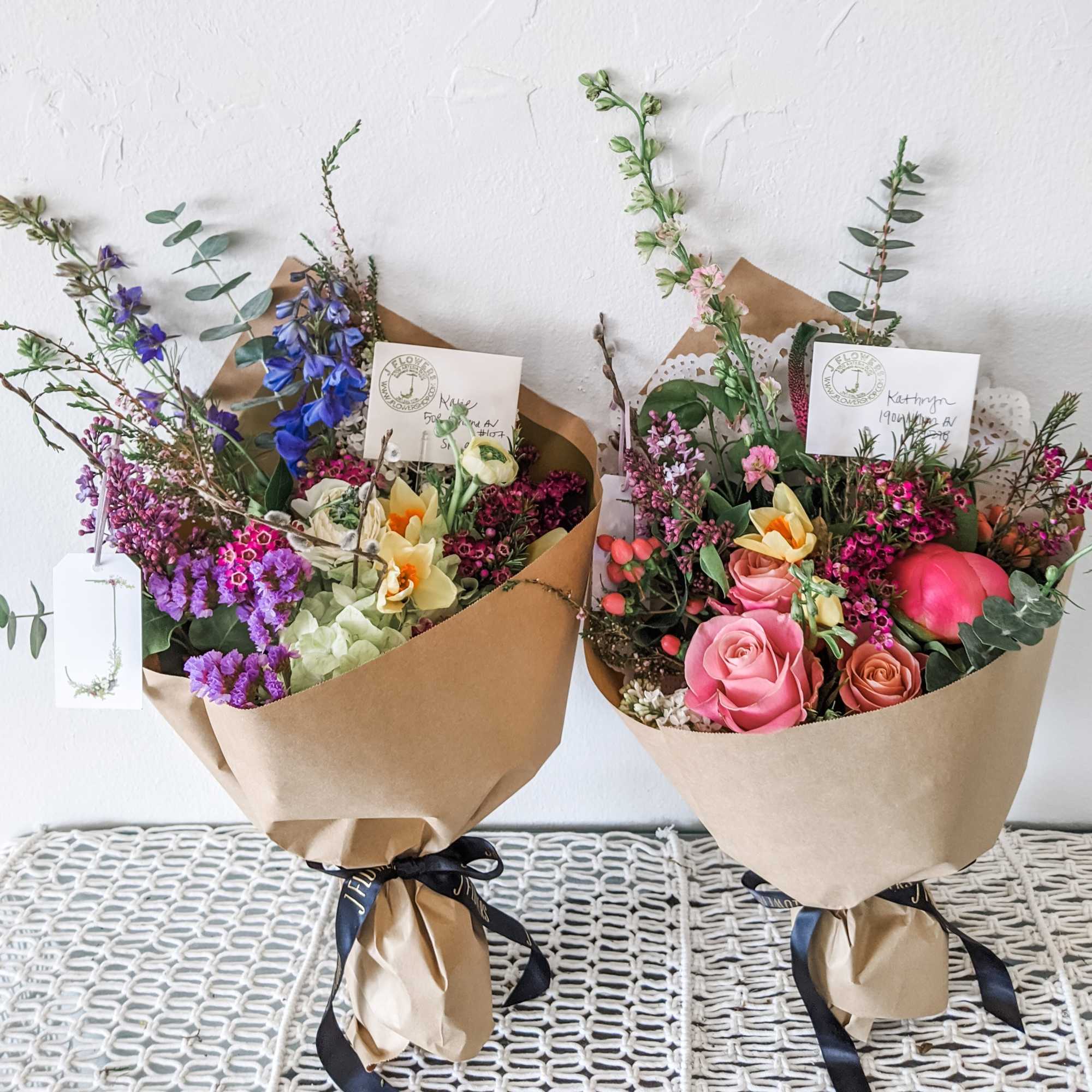 Two wrapped bouquets with pink, purple, and yellow flowers