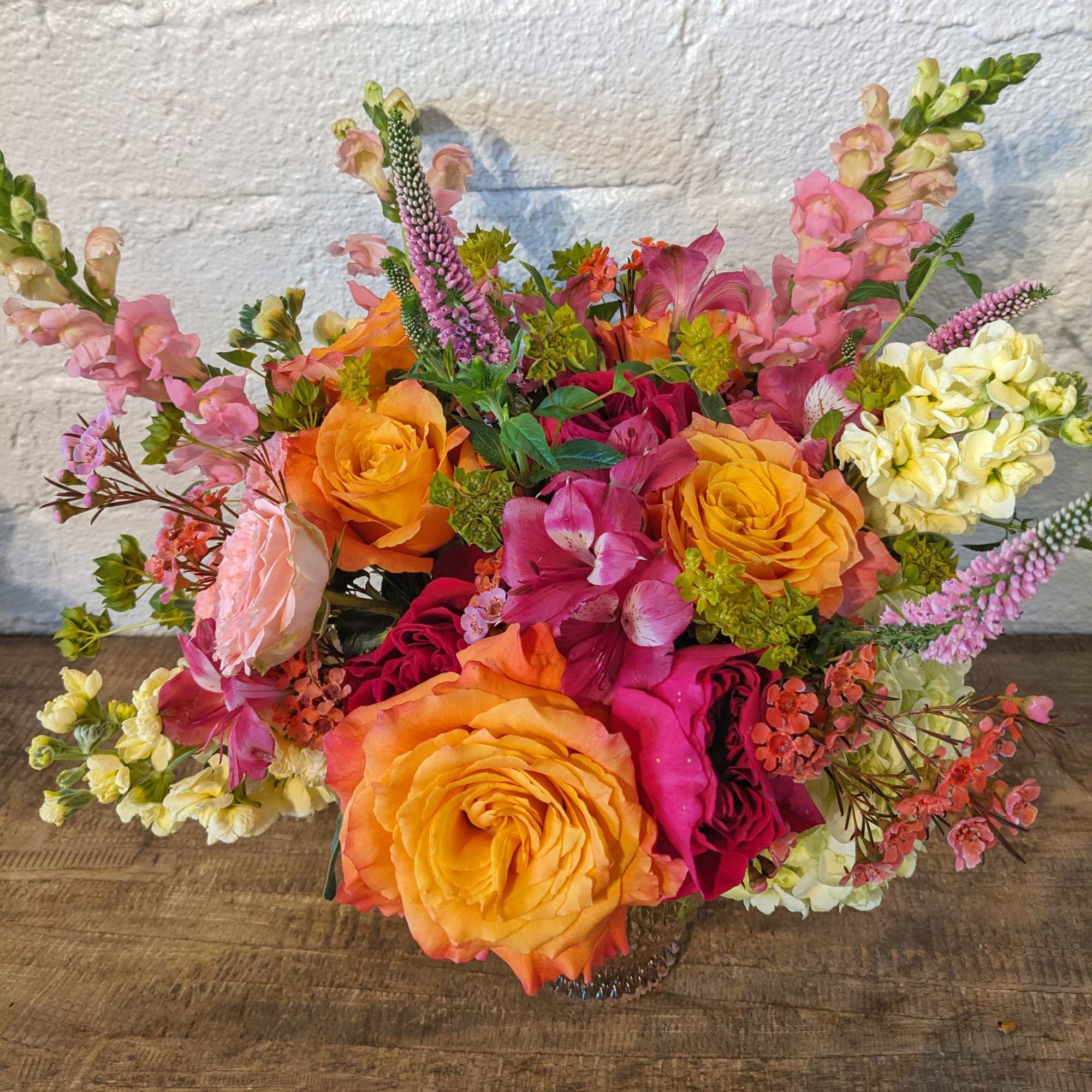 Mixed bouquet of orange and pink roses with snapdragons and alstroemeria
