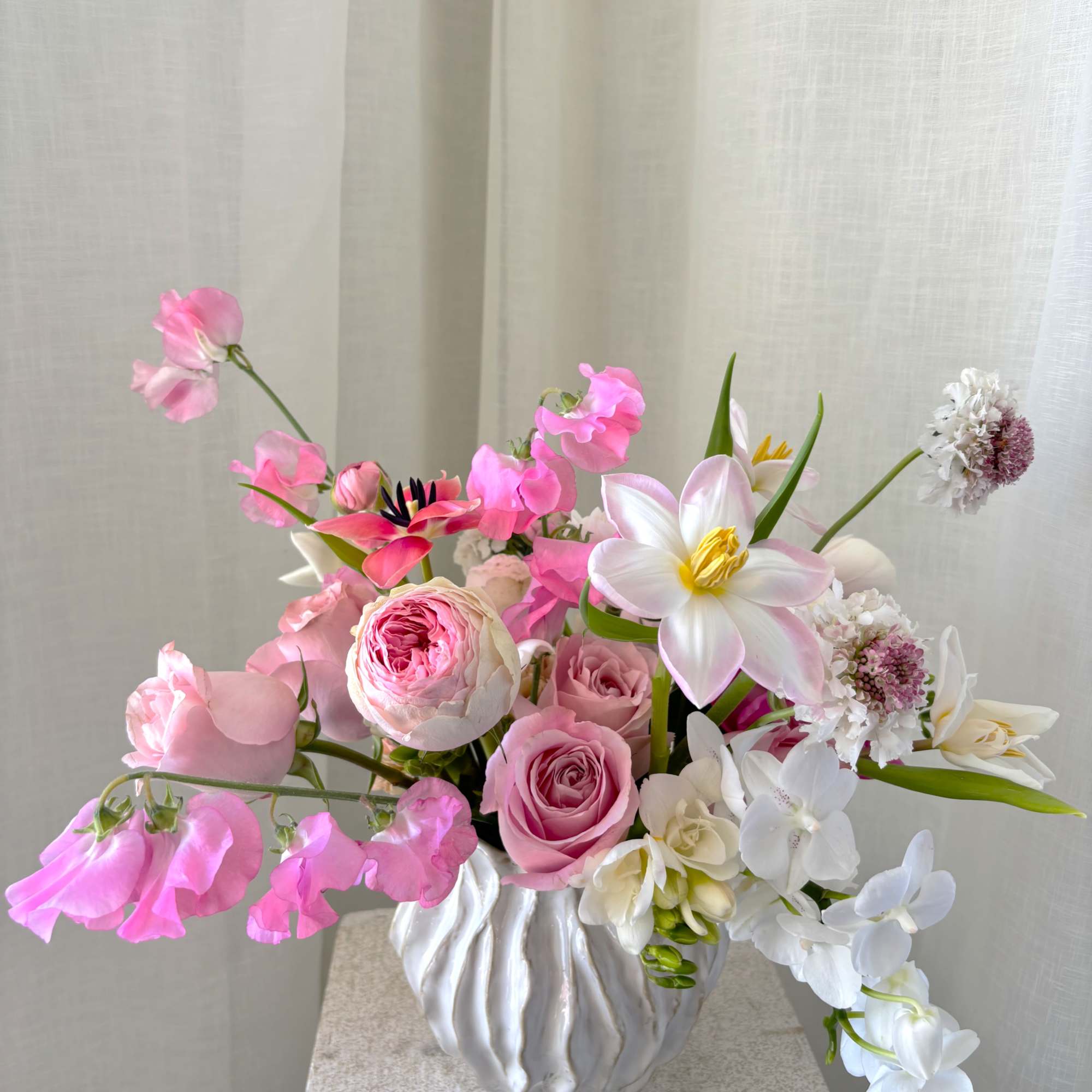 Pink and white floral arrangement in a white vase