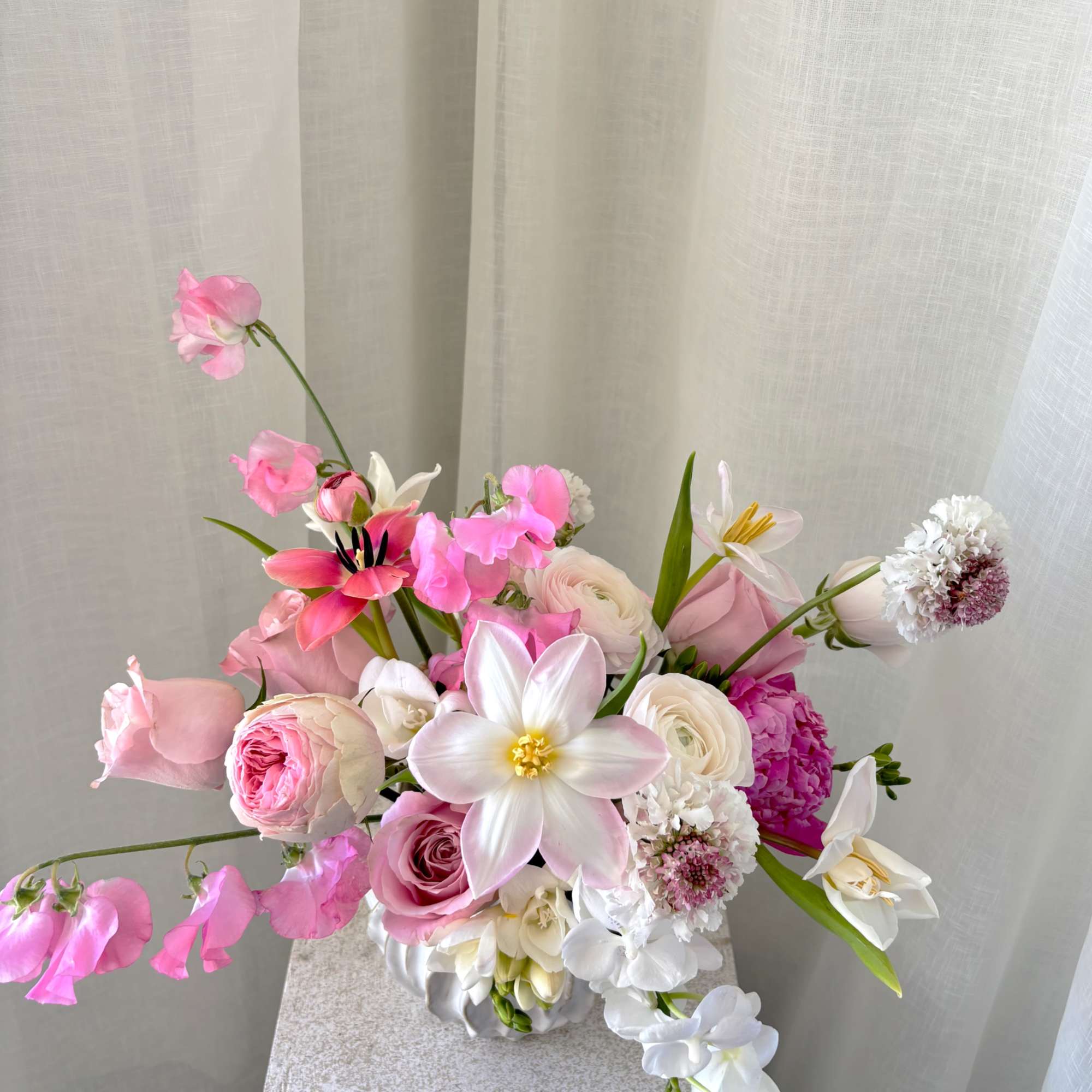 A light and airy composition of white and soft pink blooms, thoughtfully