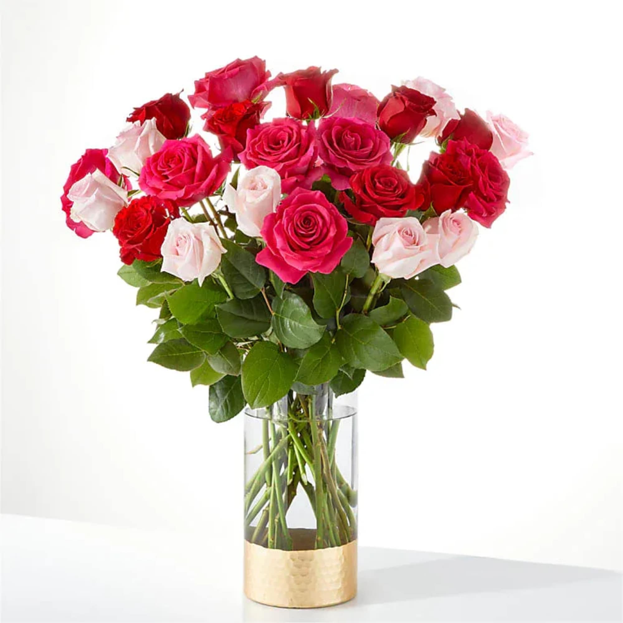 Bouquet of pink, red, and white roses in a clear glass vase