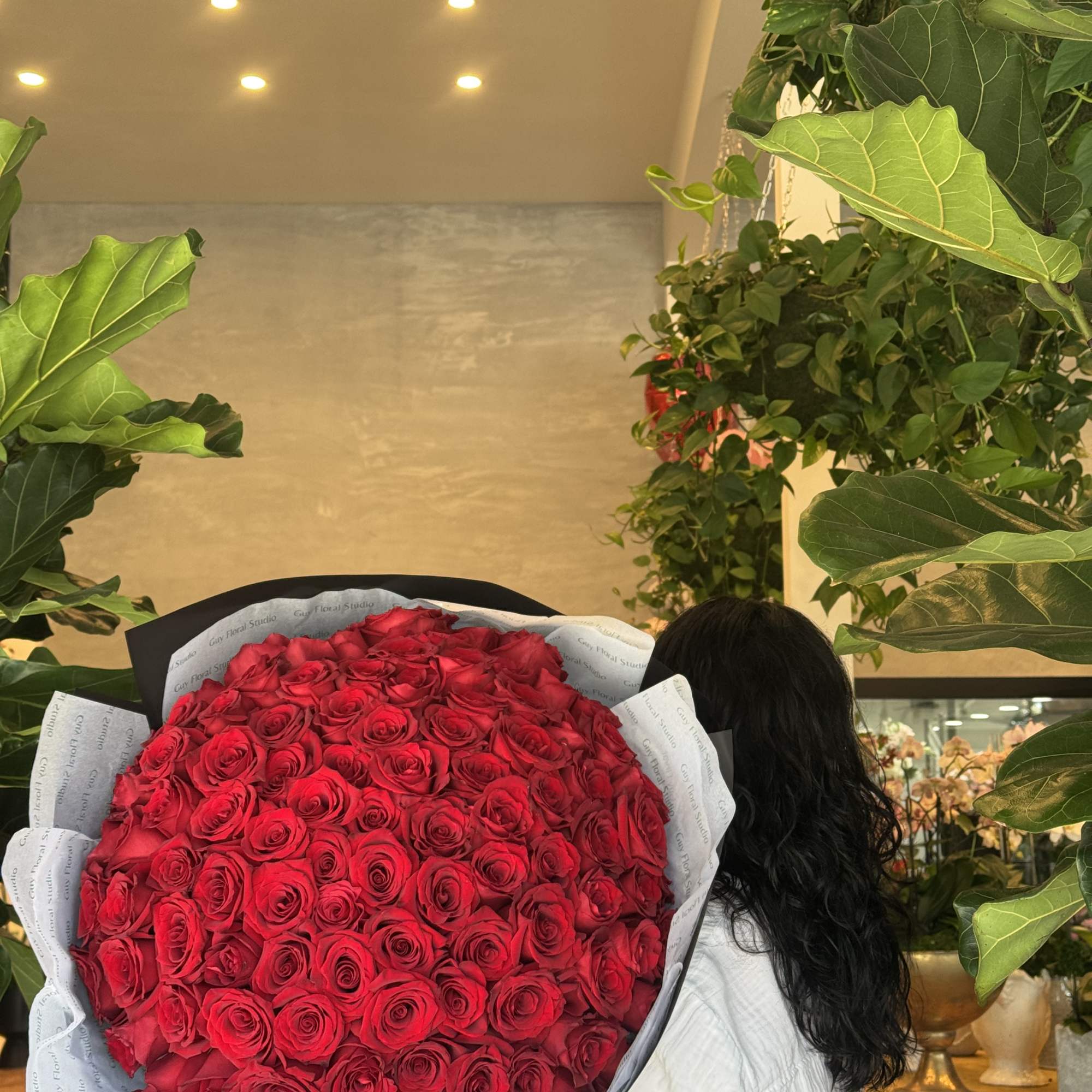 Large bouquet of red roses wrapped in black and white paper